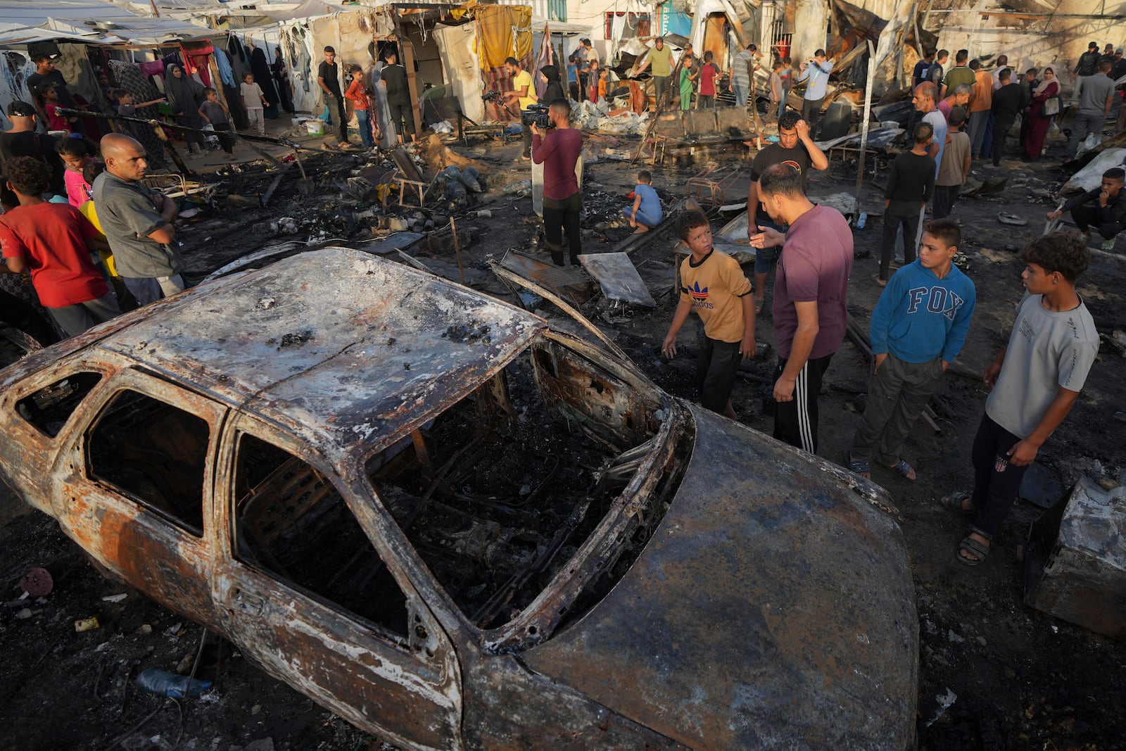 Palestinians look at the damage after an Israeli strike hit a tent area in the courtyard of Al Aqsa Martyrs hospital in Deir al Balah, Gaza Strip, Monday, Oct. 14, 2024. (AP Photo/Abdel Kareem Hana)