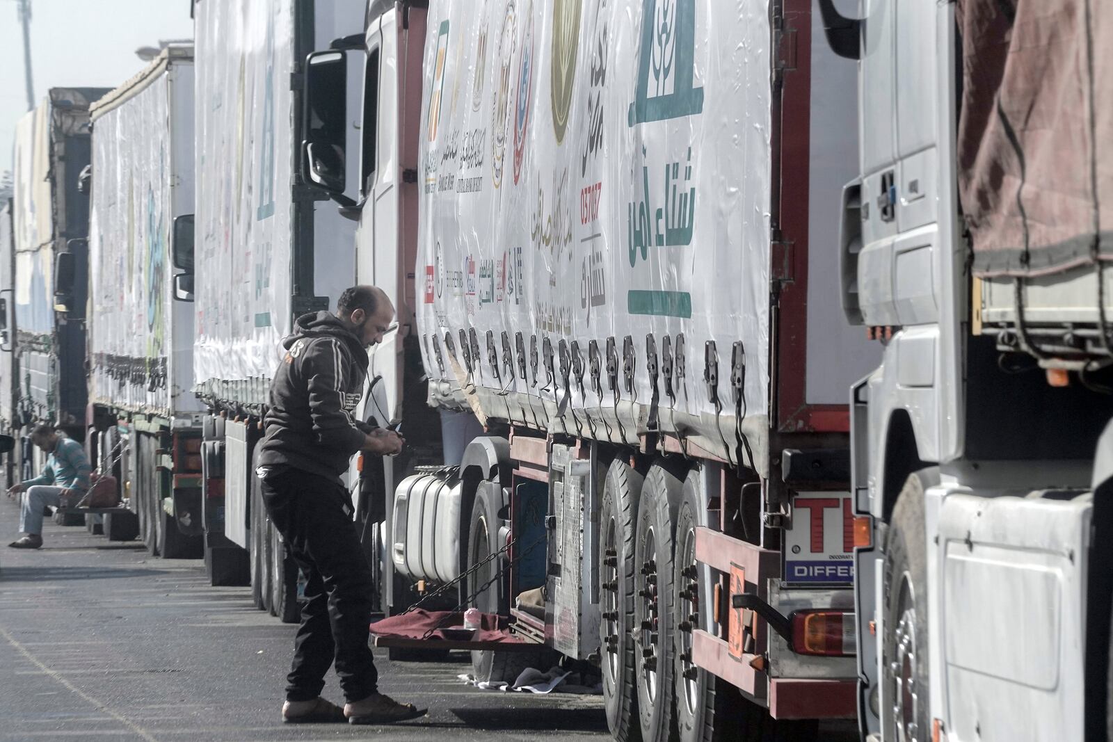 Truck drivers of humanitarian aid wait at a parking point in Cairo, Egypt, on their way to cross the Rafah border crossing between Egypt and the Gaza Strip, Sunday, Jan. 26, 2025. (AP Photo/Amr Nabil)