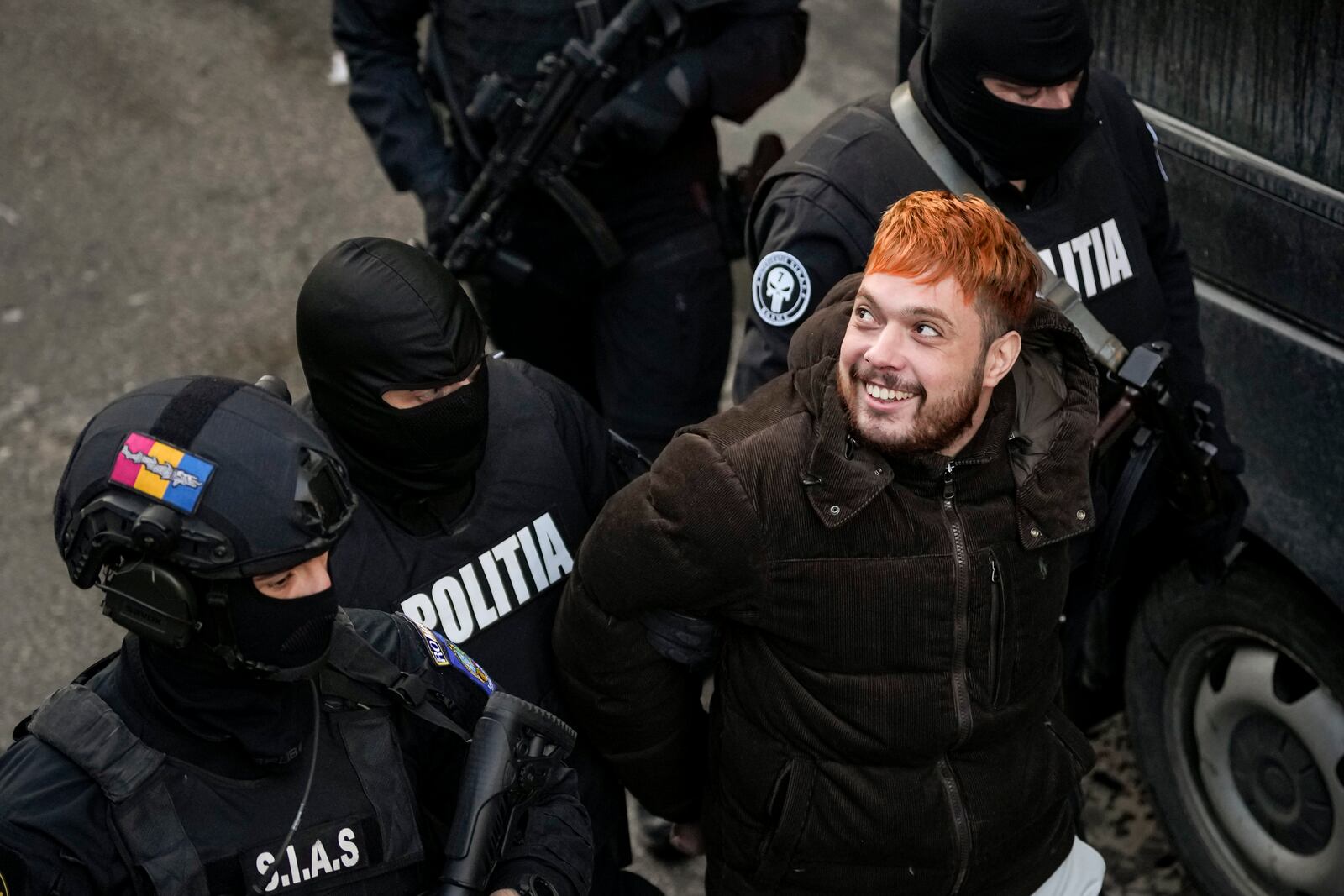 Police officers escort Mohamed Amra, nicknamed ''The Fly", after a court hearing at the Court of Appeals in Bucharest, Romania, Sunday, Feb. 23, 2025, following his arrest the day before. (AP Photo/Vadim Ghirda)