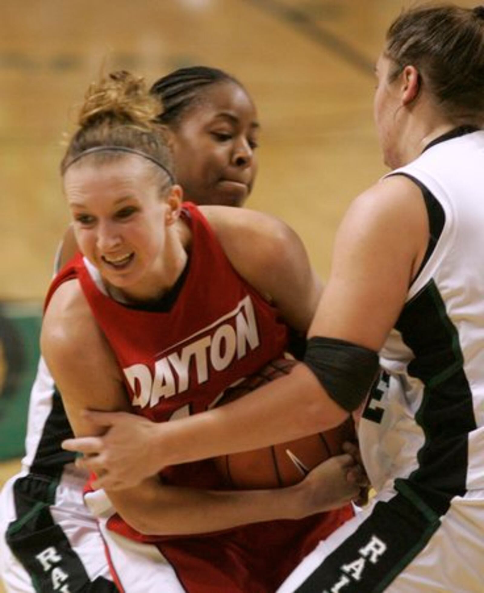 Kristin Daugherty (middle), of Dayton, is trapped by Wright State defenders Shey Peddy (top) and Molly Fox. The possession arrow was in favor of Wright State, giving them the ball. Dayton went on to win the game 59 to 56.