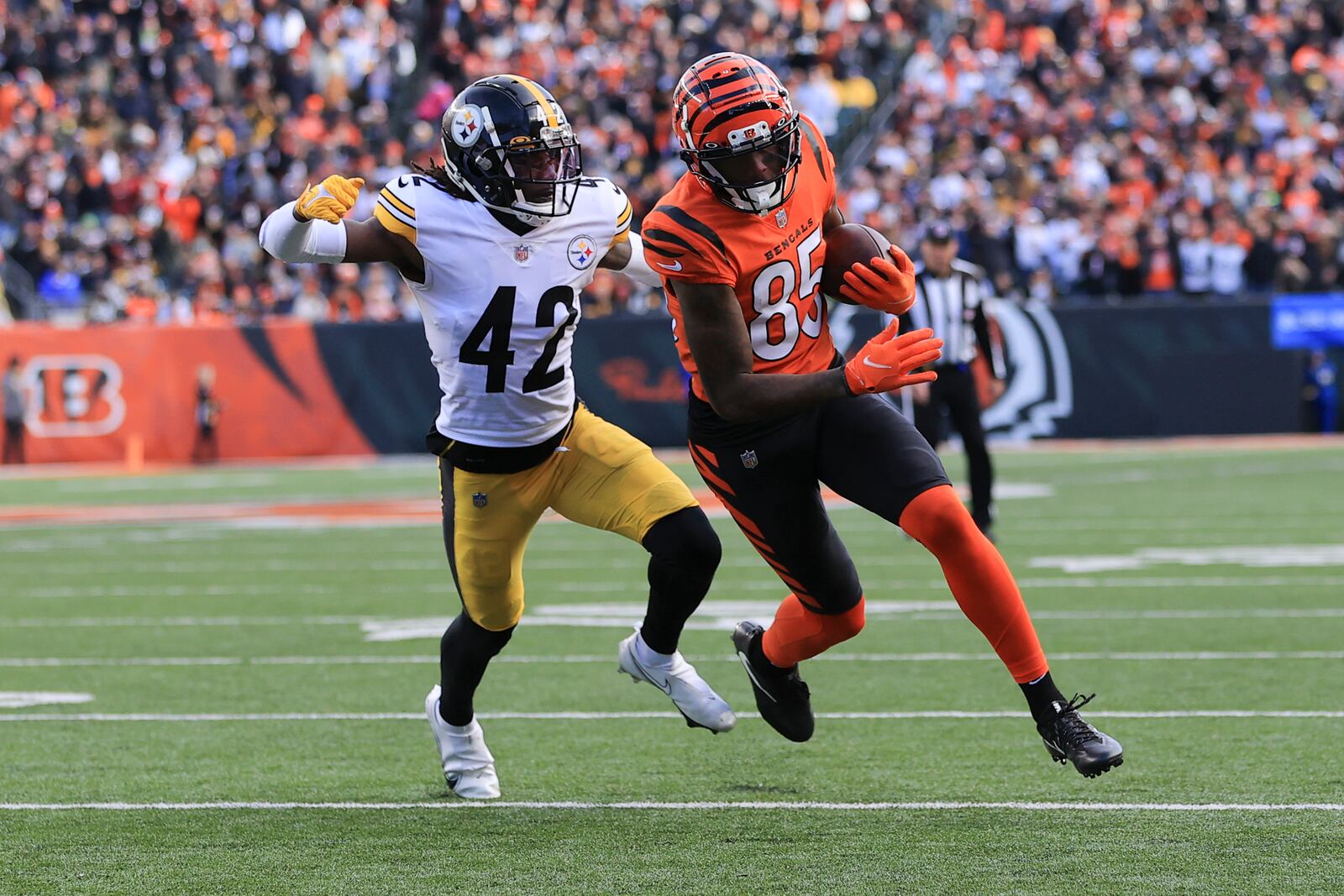 Cincinnati Bengals wide receiver Tee Higgins (85) runs away from Pittsburgh Steelers cornerback James Pierre (42) after making a catch to score a touchdown during the second half of an NFL football game, Sunday, Nov. 28, 2021, in Cincinnati. (AP Photo/Aaron Doster)