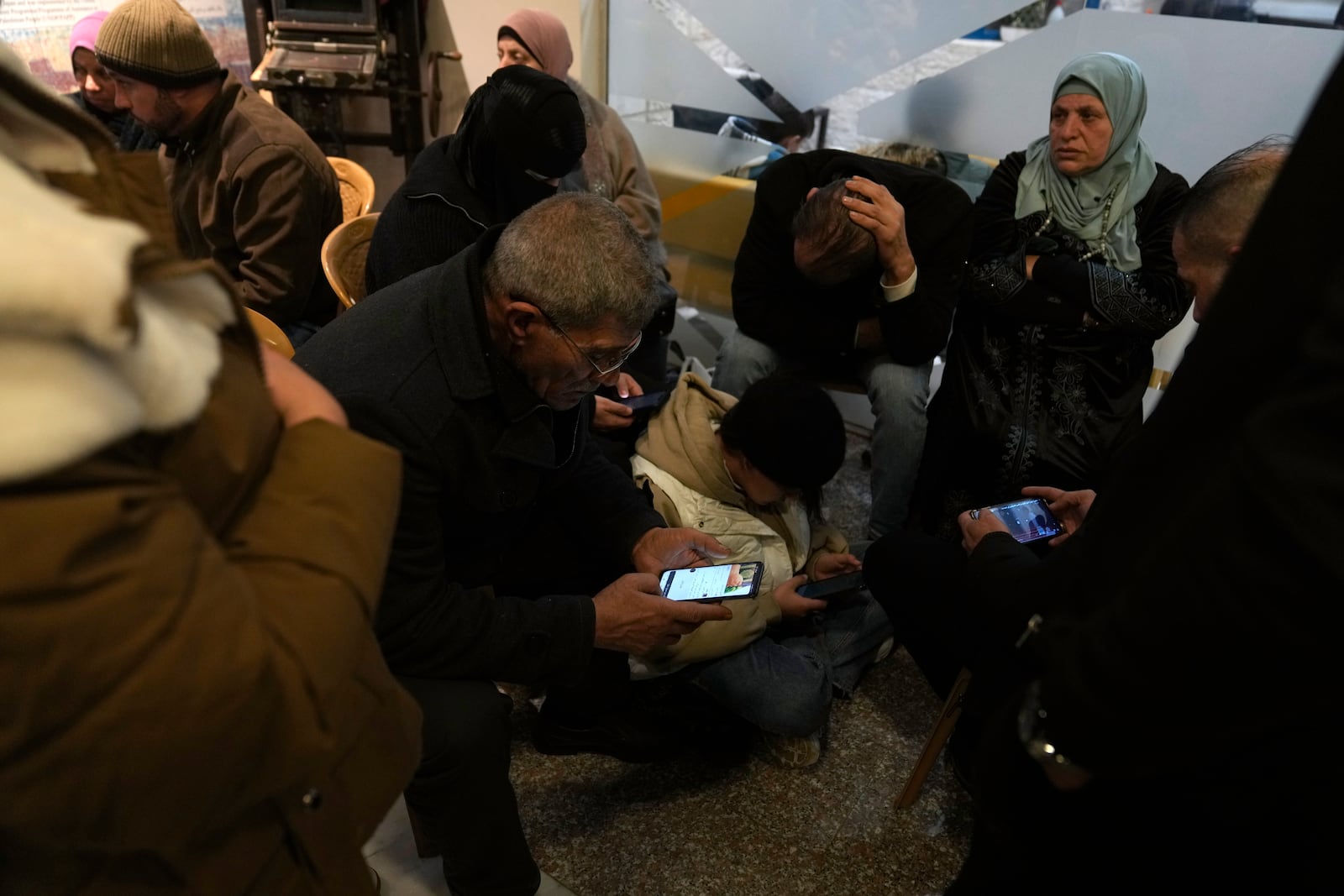 Family members waiting for the release of Palestinian prisoners follow developments Sunday, Feb. 23, 2025, after receiving news that Israel has delayed the release of hundreds of Palestinian prisoners scheduled for Saturday, in the West Bank city of Ramallah. (AP Photo/Nasser Nasser)