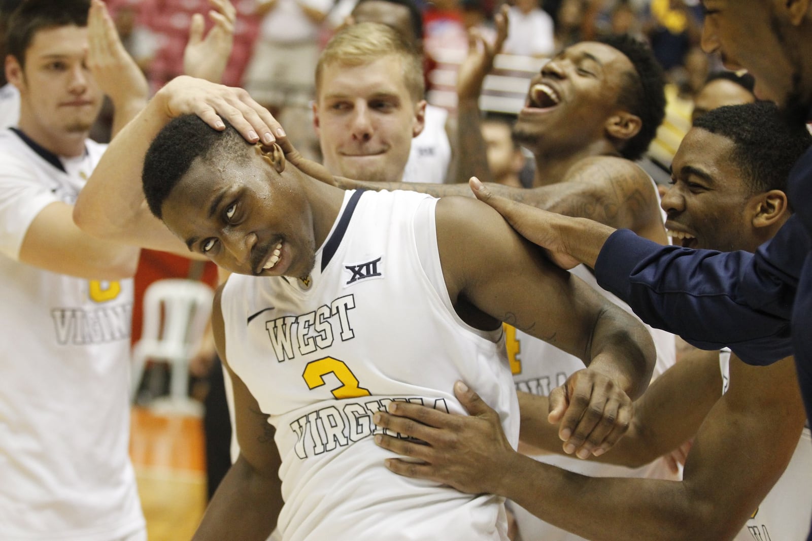 Juwan Staten celebrates with his West Virginia teammates after being named most outstanding player at the Puerto Rico Tip-Off in San Juan in November. David Jablonski/Staff