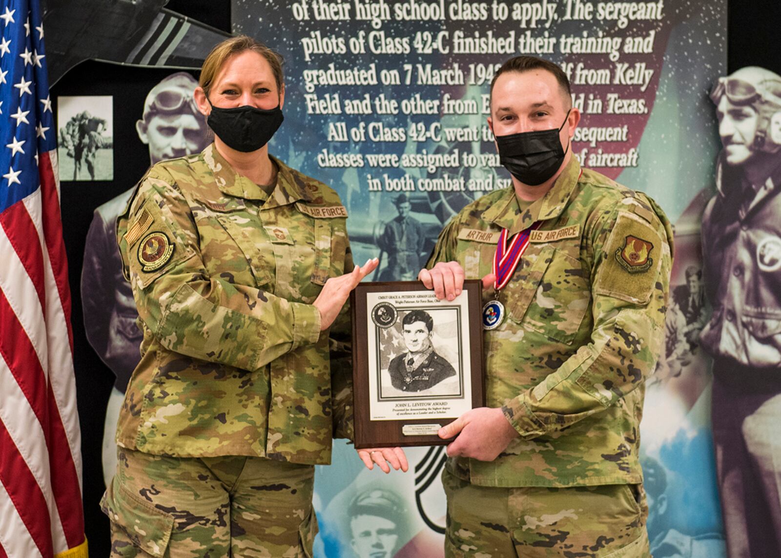 Chief Master Sgt. Lindsey Wolf, Air Force Materiel Command paralegal career field functional manager, presents Senior Airman Steven Arthur, 88th Diagnostics and Therapeutics Squadron, with the John L. Levitow Award during Airman Leadership School Class 22-B’s graduation ceremony Feb. 10 at Wright-Patterson Air Force Base. The Levitow Award goes to the top graduate. U.S. AIR FORCE PHOTO/JAIMA FOGG