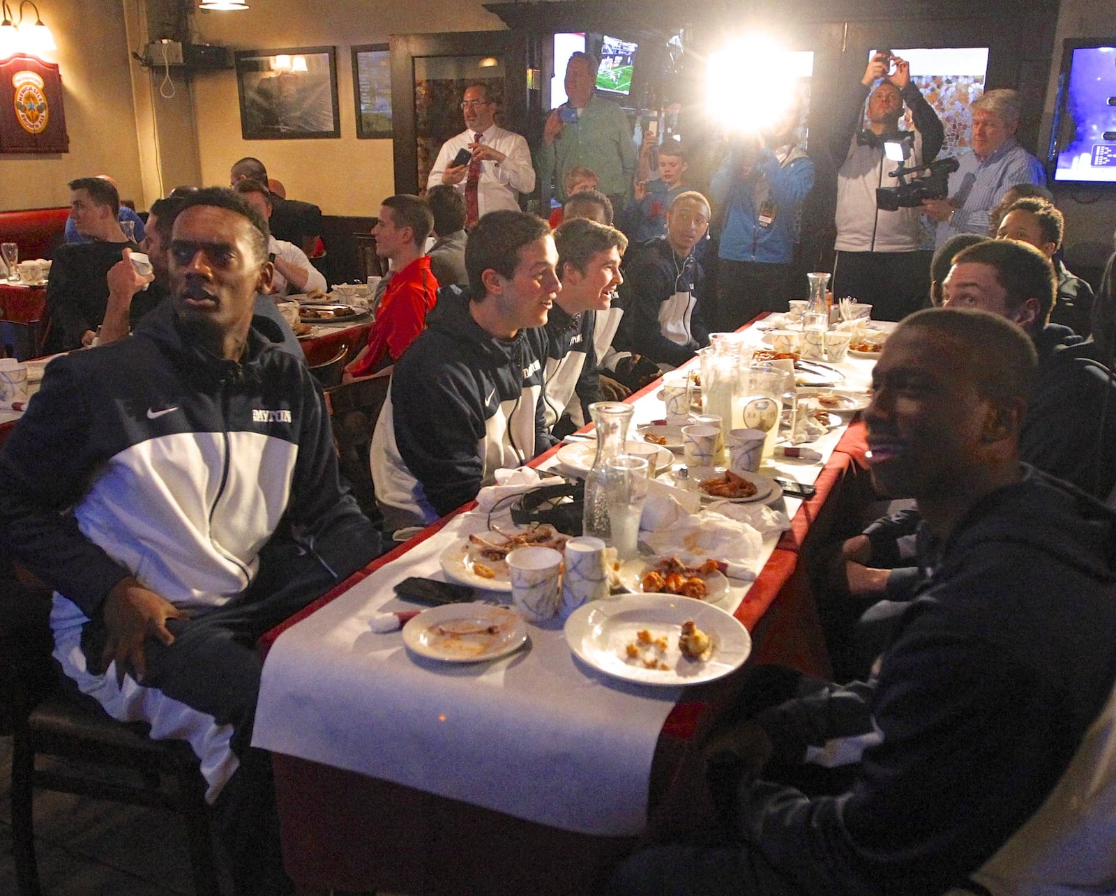 Dayton players react in shock after hearing they’ll play in the First Four. The Flyers watched the NCAA tournament selection show at Burke’s Restaurant and Bar in Yonkers, N.Y., on the way to the airport after a loss to Virginia Commonwealth in the Atlantic 10 championship game in Brooklyn. DAVID JABLONSKI / STAFF