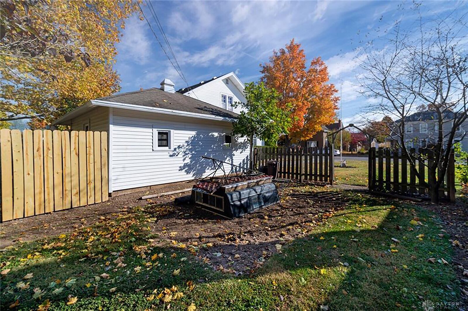 The back yard is fully fenced and has mature trees. The detached garage has a concrete walkway leading to the house.