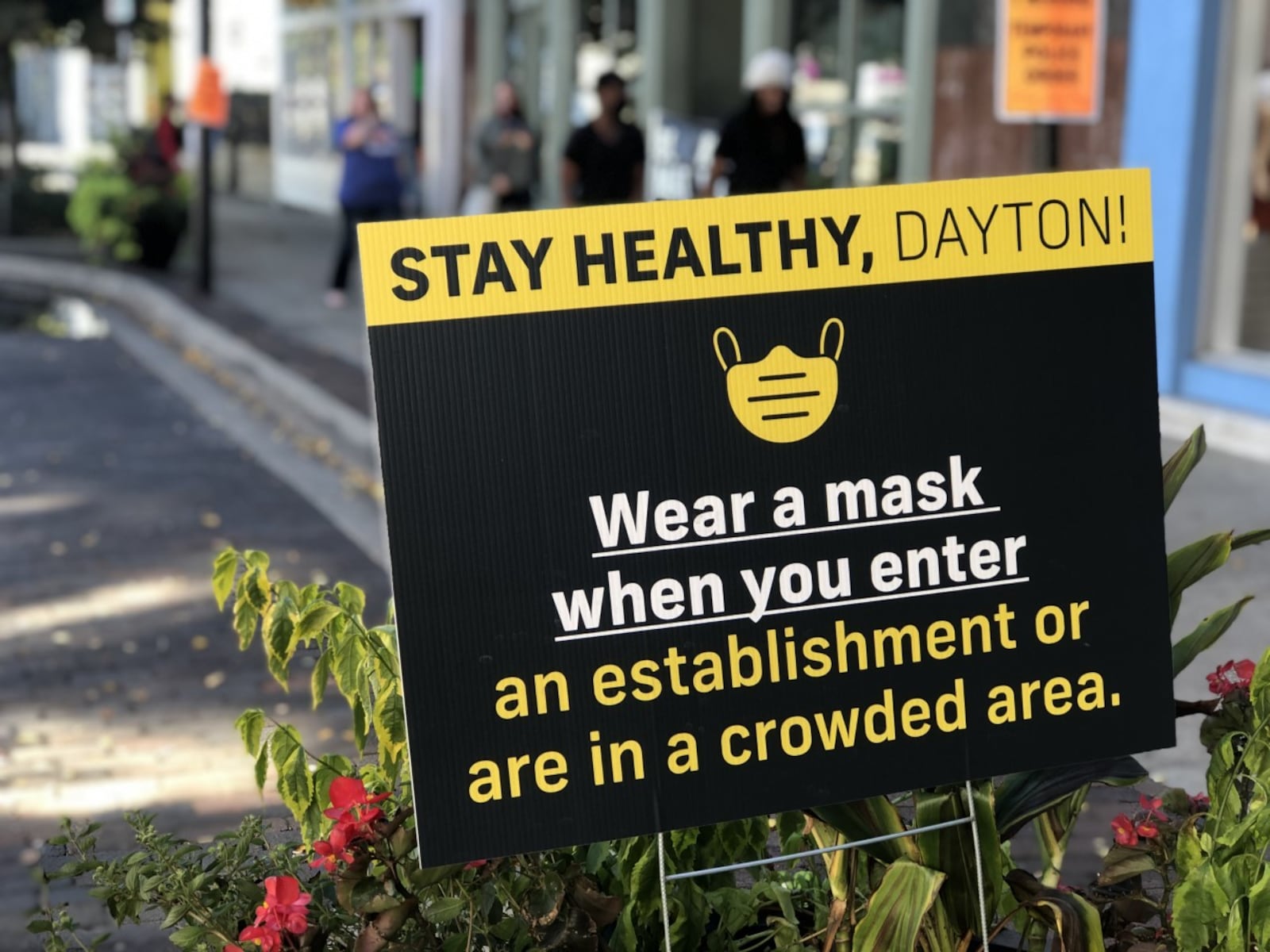 Signs have been posted throughout the Oregon District asking visitors to wear masks and socially distance. CORNELIUS FROLIK / STAFF