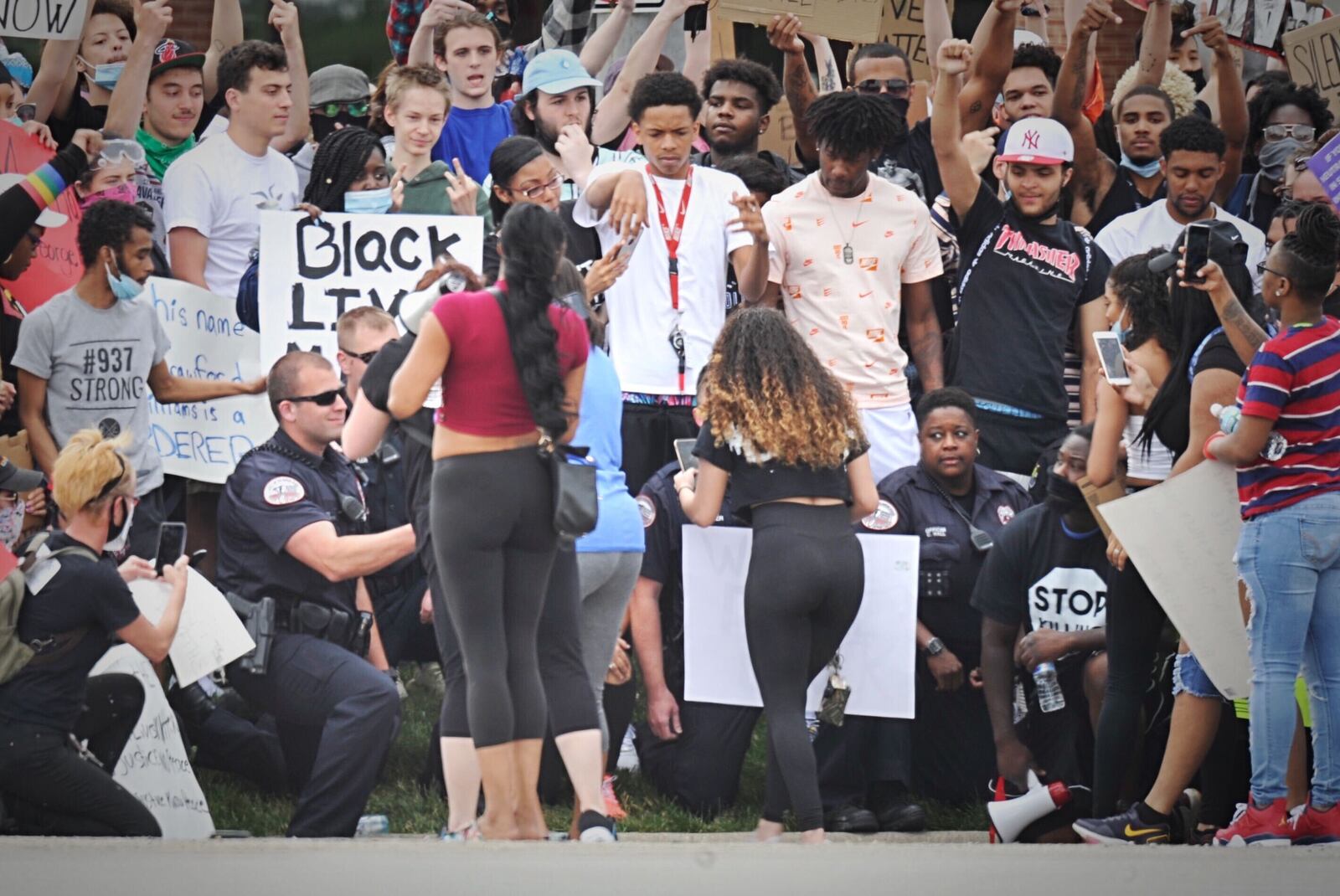 Before the protest, teargas was deployed when people blocked an intersection,but by the end demonstrators and police  got down on one knee together as sign of solidarity. PHOTOS: Marshall Gorby, Jim Noelker