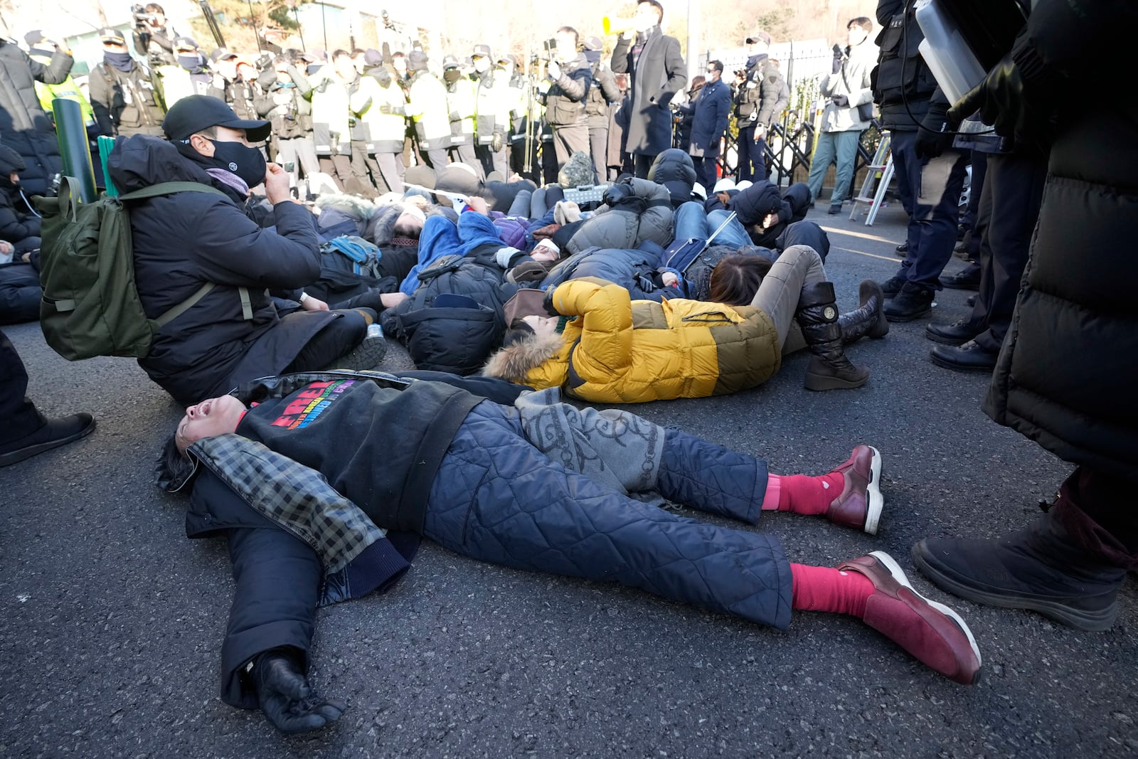 Supporters of impeached South Korean President Yoon Suk Yeol lie down on the ground as Yoon faces potential arrest after a court on Tuesday approved a warrant for his arrest, near the presidential residence in Seoul, South Korea, Thursday, Jan. 2, 2025. (AP Photo/Ahn Young-joon)