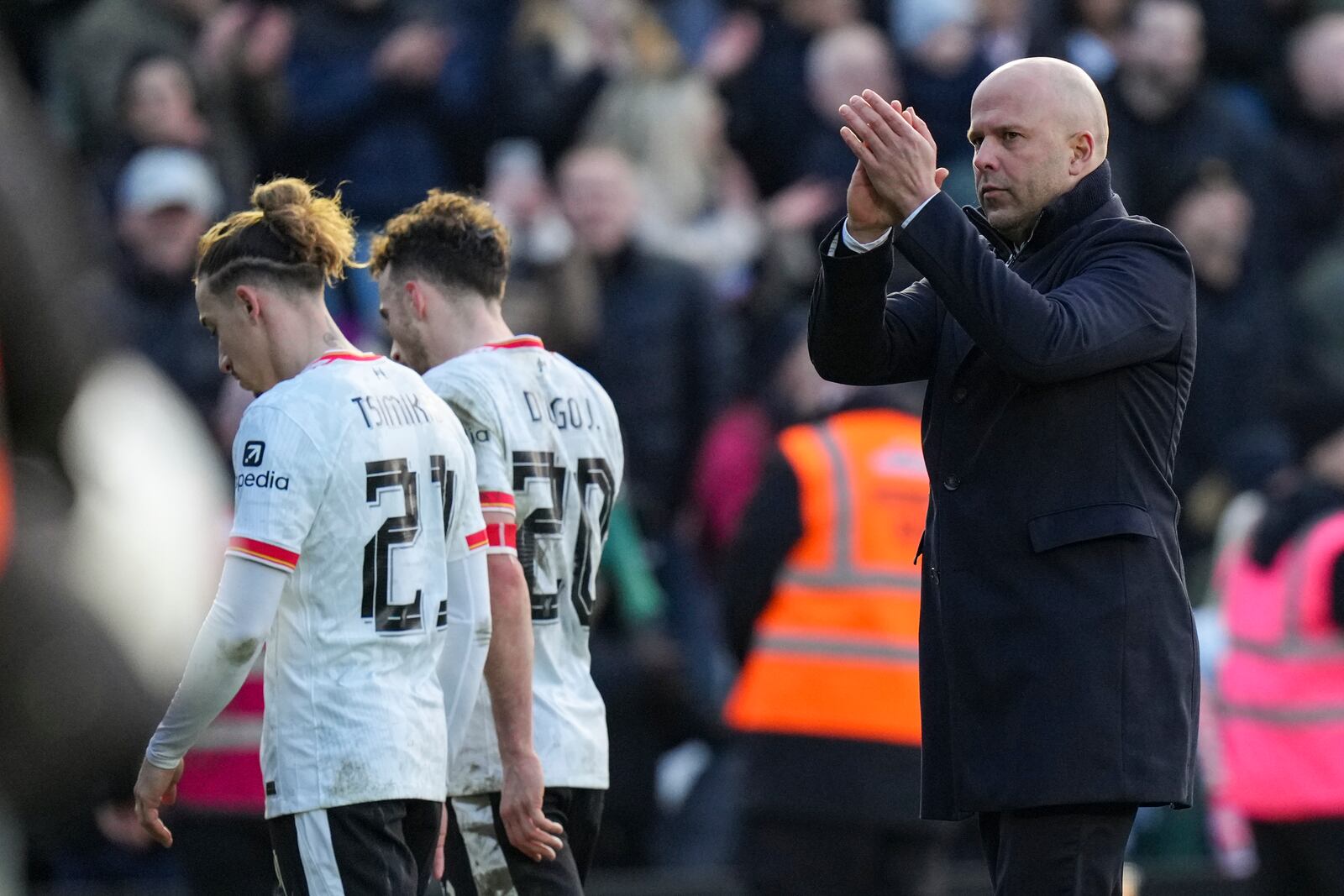 Liverpool's manager Arne Slot applauds as Liverpool's Diogo Jota and Kostas Tsimikas walk off the pitch after the English FA Cup fourth round soccer match between Plymouth Argyle and Liverpool at Home Park stadium in Plymouth, England, Sunday, Feb. 9, 2025. (AP Photo/Alastair Grant)