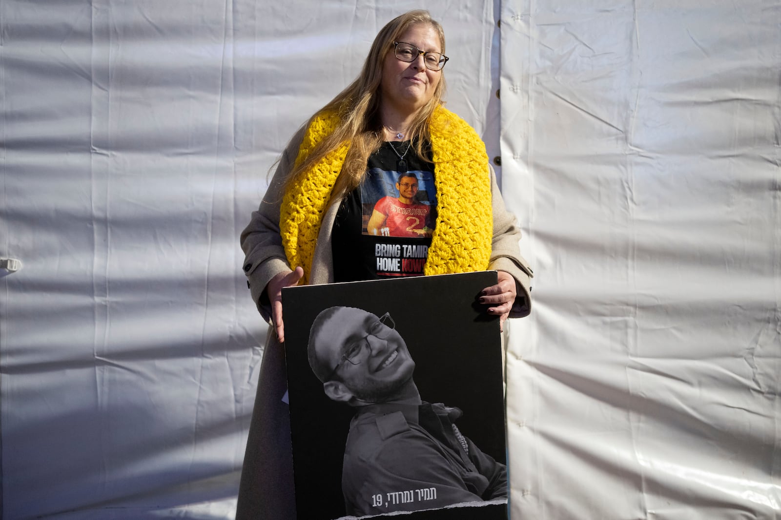 Herut Nimrodi poses for a portrait with a poster of her son, Tamir Nimrodi, an Israeli soldier taken hostage on Oct. 7, 2023, and being held by Hamas militants in the Gaza Strip, at a rally for hostages and their families in Tel Aviv, Israel, on Tuesday, Jan. 14, 2025. (AP Photo/Maya Alleruzzo)