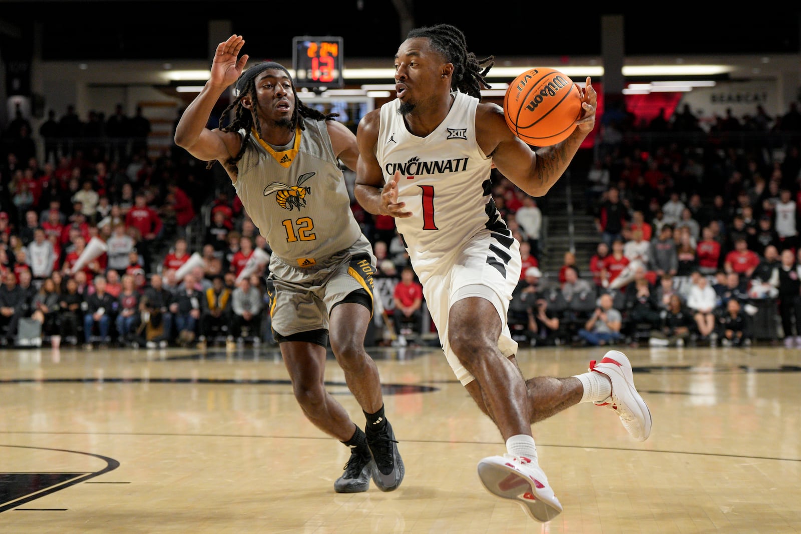 Cincinnati guard Day Day Thomas (1) dribbles against Alabama State's Shawn Fulcher (12) during the first half of an NCAA college basketball game, Wednesday, Nov. 27, 2024, in Cincinnati. (AP Photo/Jeff Dean)