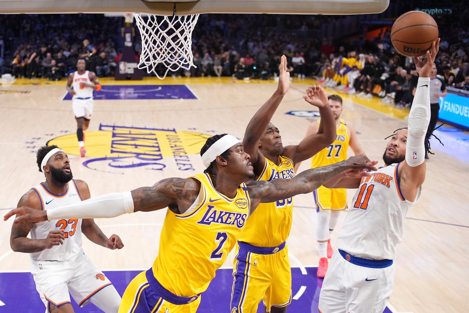 New York Knicks guard Jalen Brunson (11) shoots as Los Angeles Lakers forward Jarred Vanderbilt (2) and center Trey Jemison III (55) defend during the first half of an NBA basketball game Thursday, March 6, 2025, in Los Angeles. (AP Photo/Mark J. Terrill)