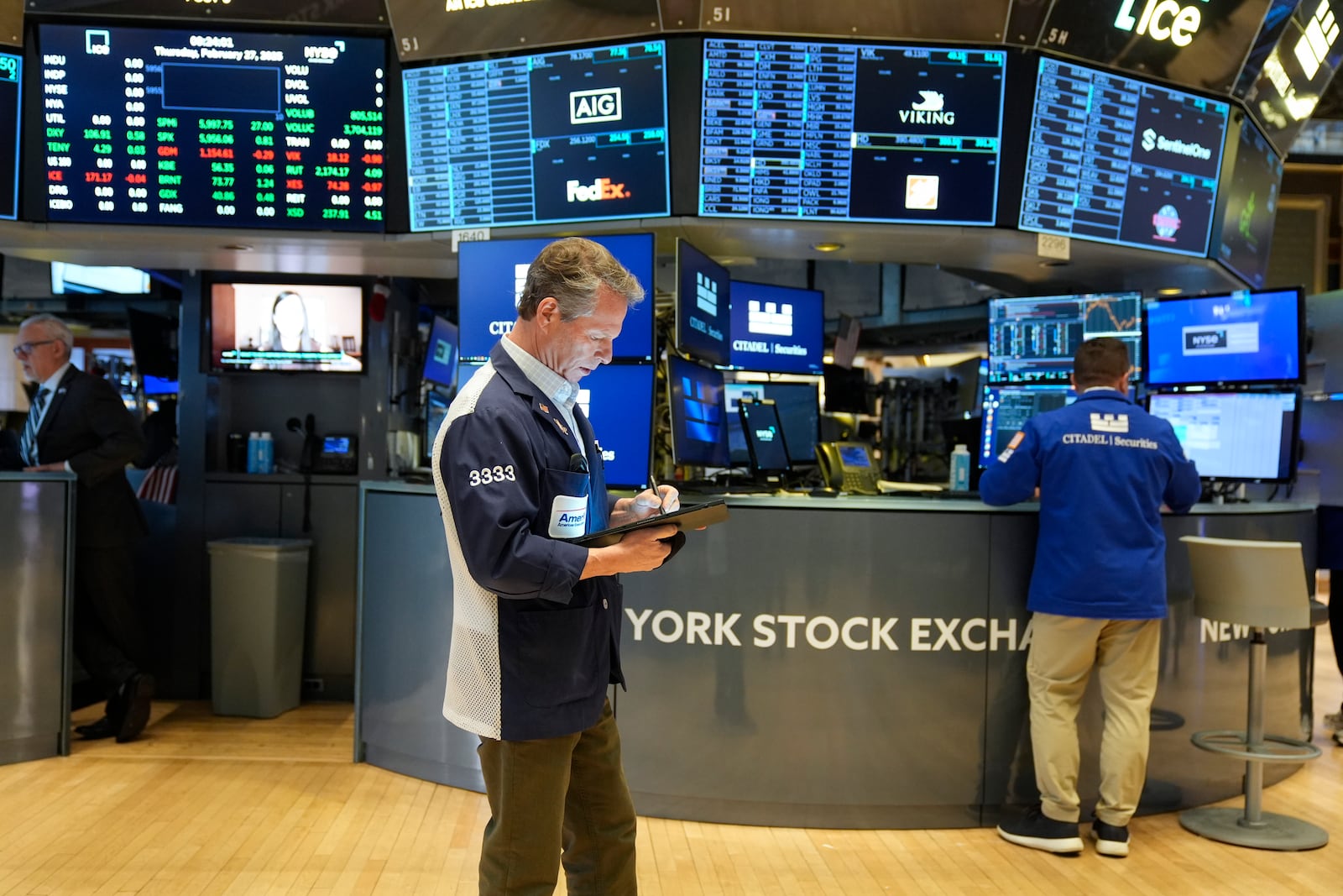 People work on the floor at the New York Stock Exchange in New York, Thursday, Feb. 27, 2025. (AP Photo/Seth Wenig)