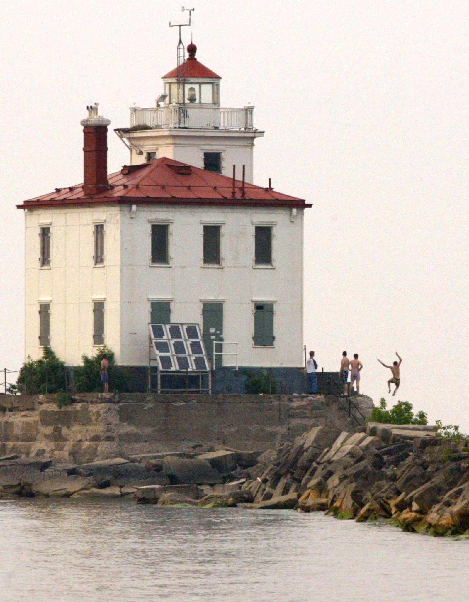 The lighthouse at the entrance to Fairport Harbor is used by kids as a diving board into Lake Erie. The channel at that point is said to be about 40 feet deep.  STAFF PHOTO BY BILL REINKE.