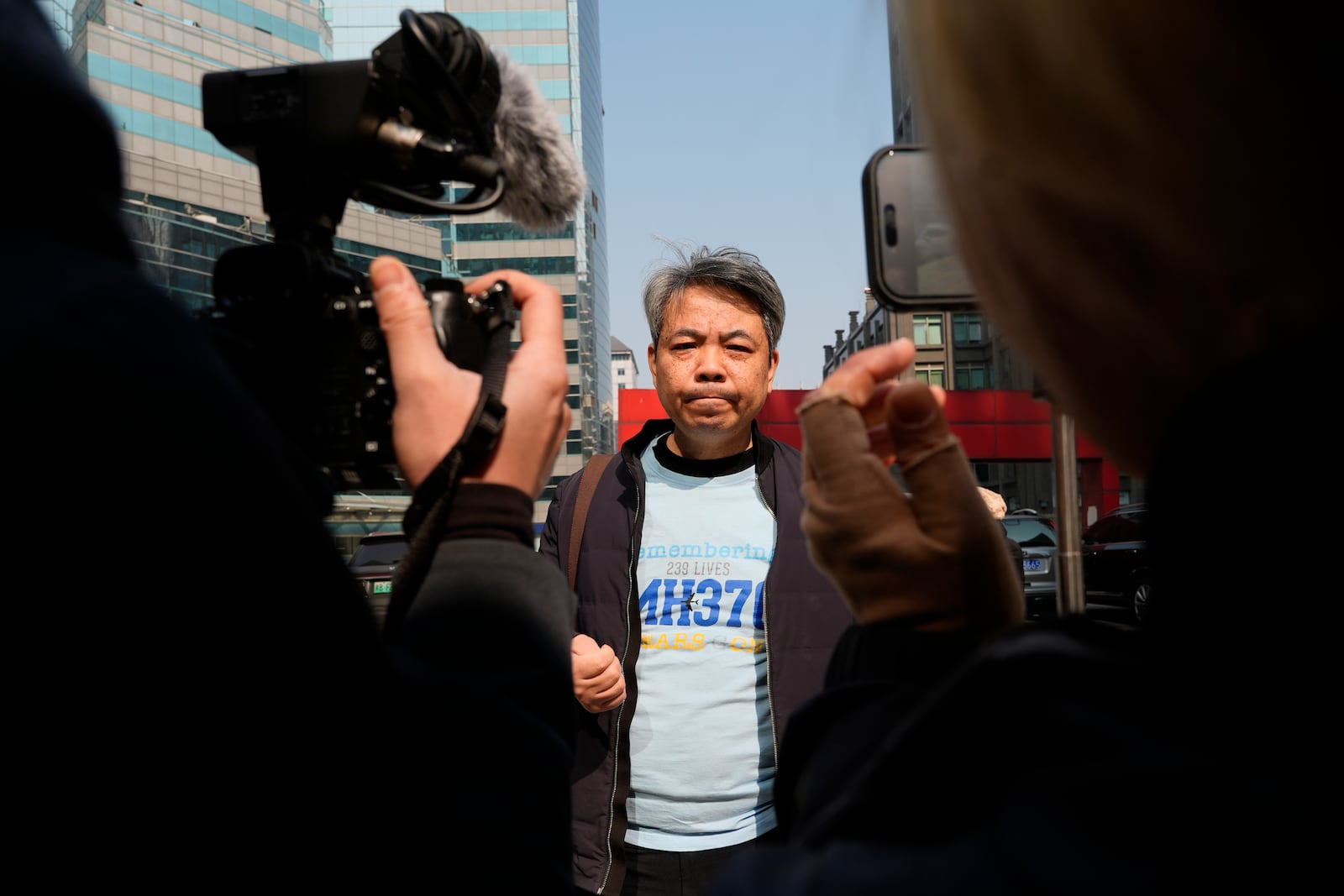 Jiang Hui, whose mother was on the missing MH370 Malaysia Airlines passenger jet, wears a shirt "Remembering 239 Lives, MH370" as he talks to media on the 11th anniversary of the jet going missing, Saturday, March 8, 2025, in Beijing, China. (AP Photo/Ng Han Guan)