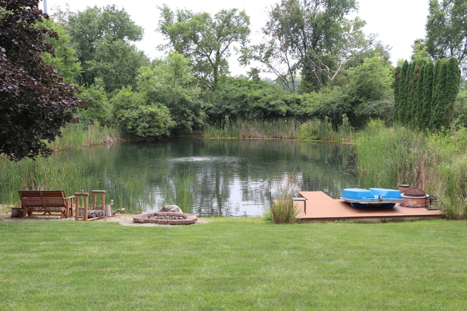 The pond is nestled among the trees and has an irrigation fountain, beach boat launch and boat deck.