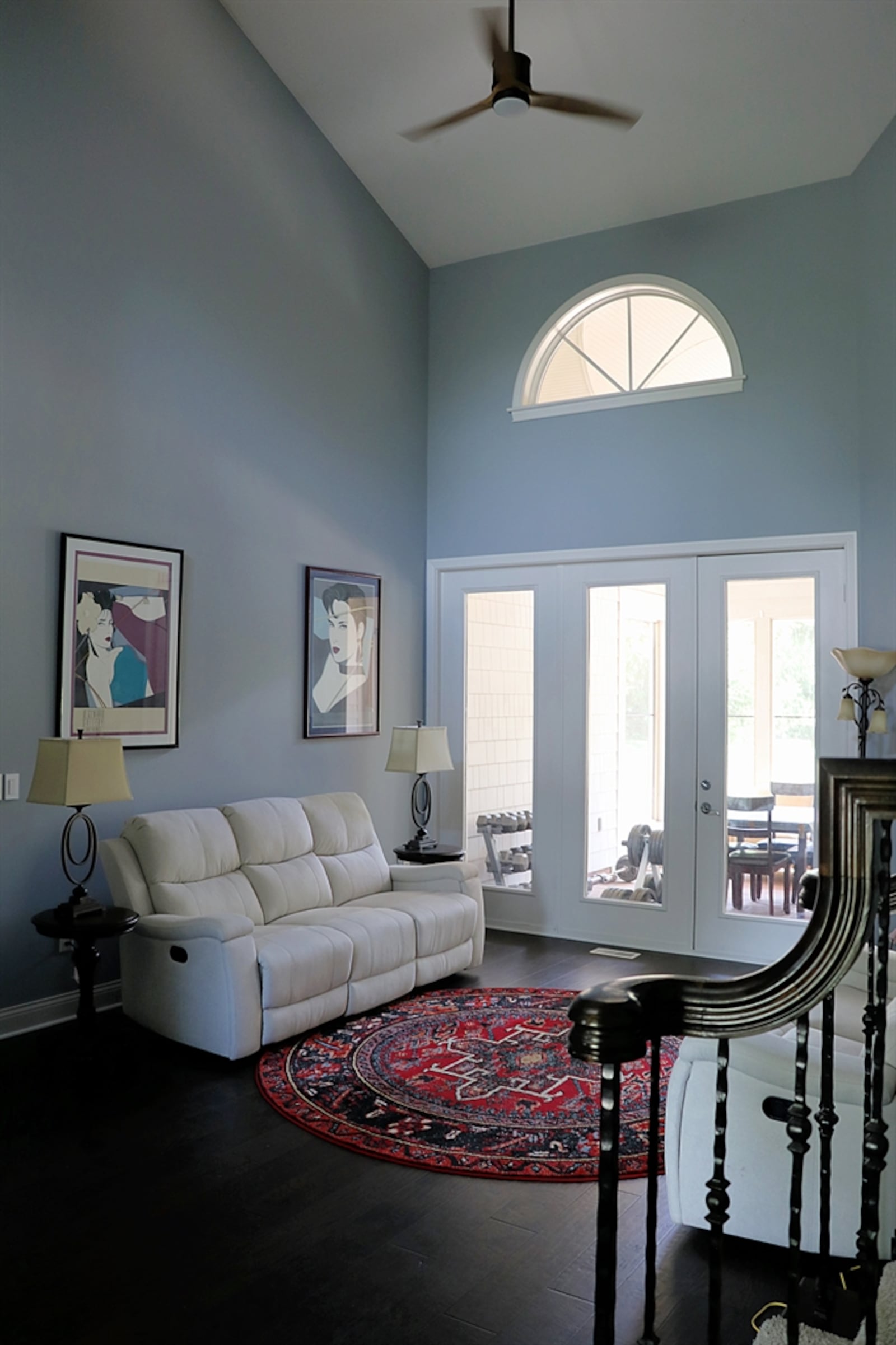 The great room has a high ceiling and an arched window above triple-glass patio doors that open to a screen-enclosed porch. Contributed photo by Kathy Tyler 