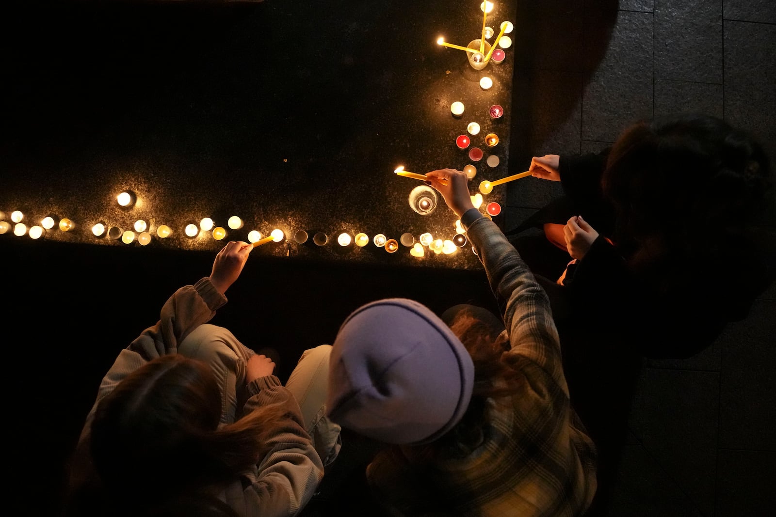 People light candles for the victims after an outdoor roof collapsed at a train station in Novi Sad, Serbia, Friday, Nov. 1, 2024. (AP Photo/Darko Vojinovic)