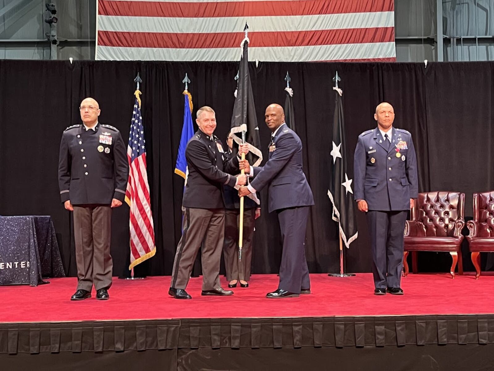 Space Force Col Marcus Starks, to the immediate right of the military guidon or banner, accepted command of the National Space Intelligence Center at Wright-Patterson Air Force Base Friday. Handing off the guidon, on the banner's immediate left, was Maj. Gen. Gregory Gagnon. THOMAS GNAU/STAFF