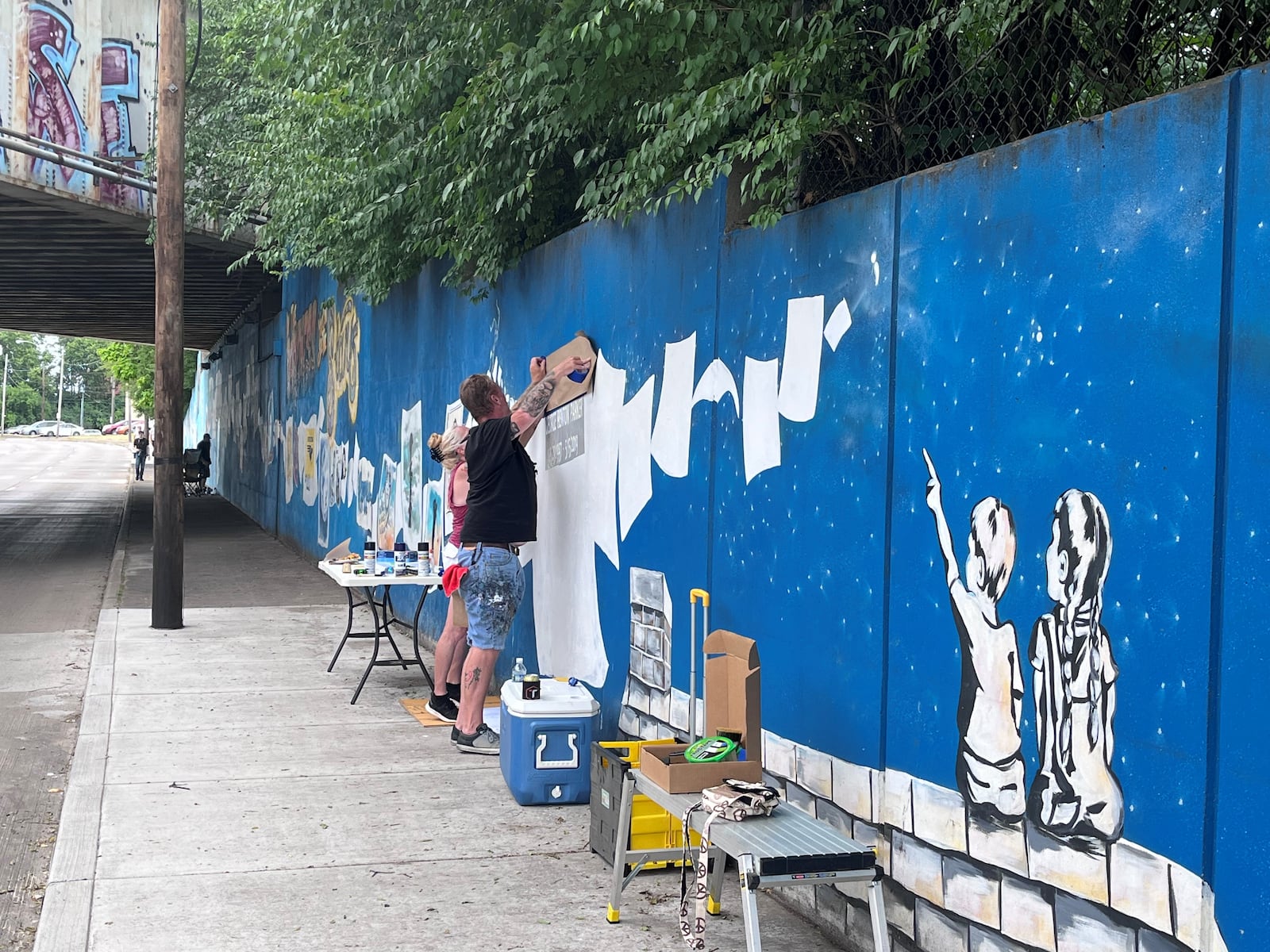 Community members painting on the suicide awareness and prevention mural on Keowee Street in Dayton. STAFF