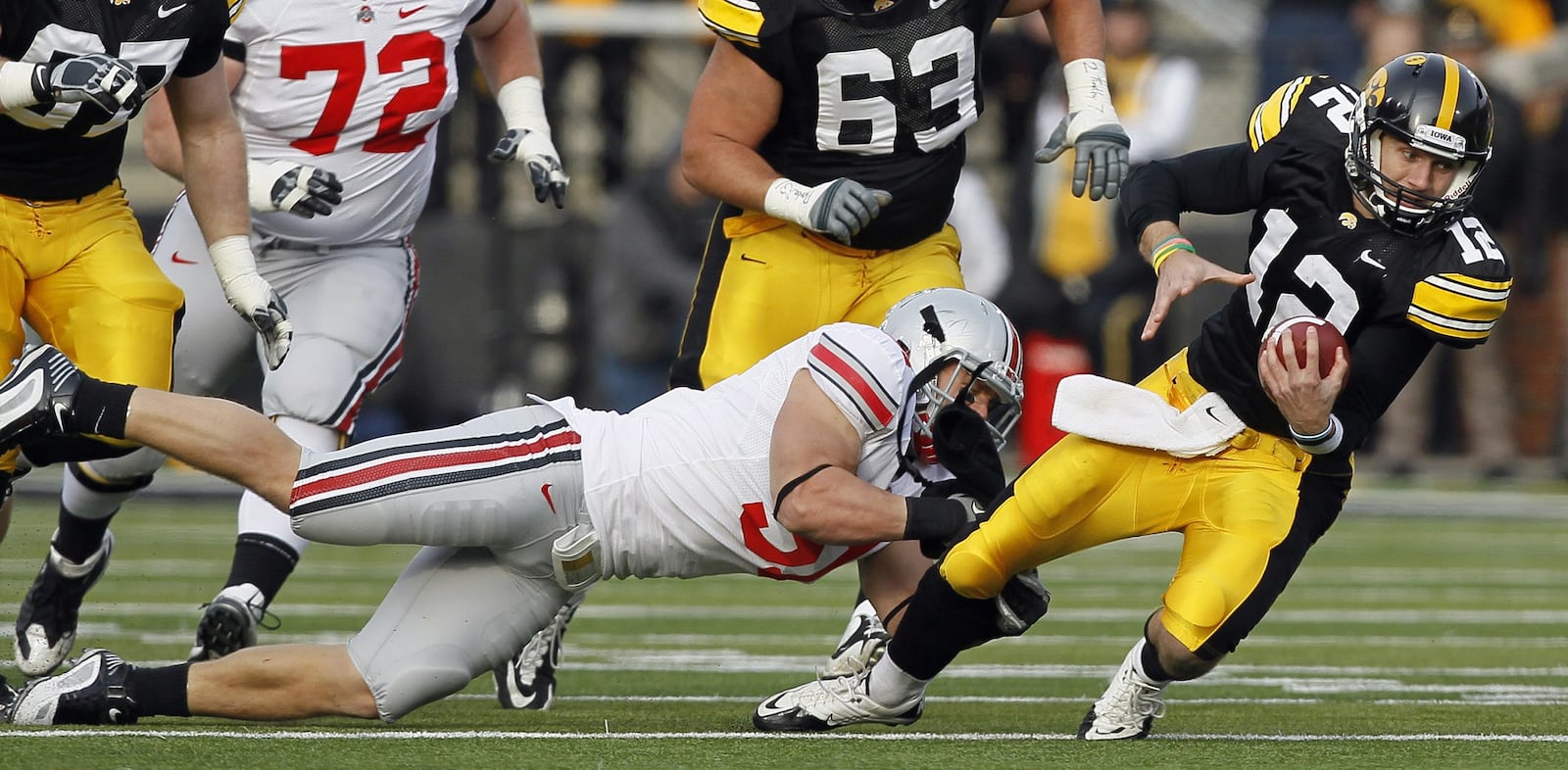 Iowa quarterback Ricky Stanzi (12) is tackled by Ohio State linebacker Ross Homan during the first half of an NCAA college football game, Saturday, Nov. 20, 2010, in Iowa City, Iowa. Ohio State won 20-17. (AP Photo/Charlie Neibergall)