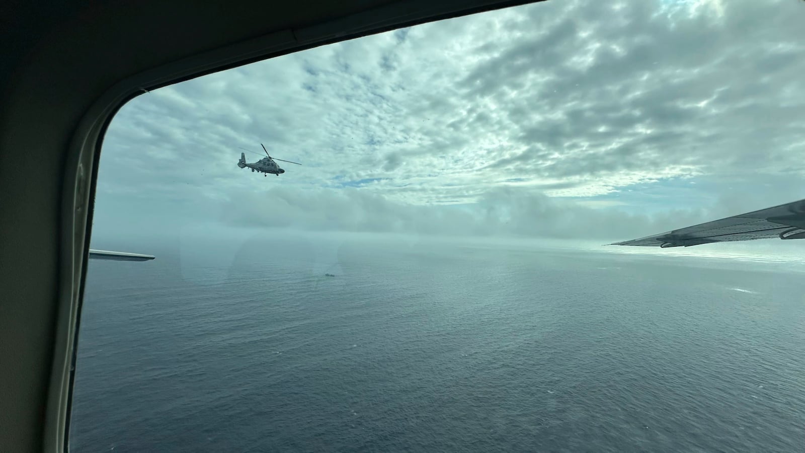 A Chinese military helicopter flies close to a Philippine Bureau of Fisheries and Aquatic (BFAR) aircraft above Scarborough shoal on Tuesday, Feb. 18, 2025. (AP Photo/Joeal Calupitan)