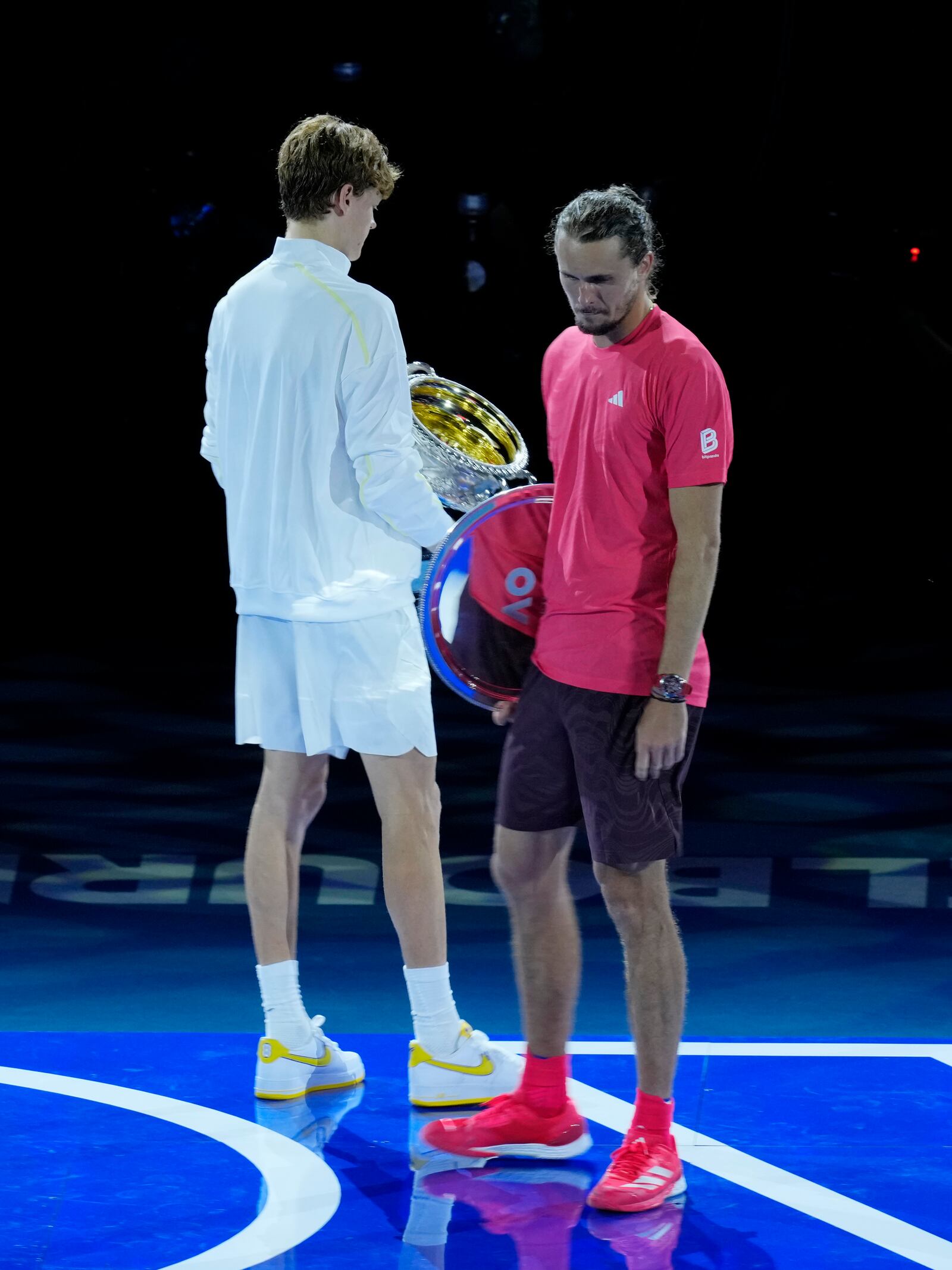 Alexander Zverev of Germany, right, turns to leave the stage after he congratulated Jannik Sinner of Italy following the men's singles final at the Australian Open tennis championship in Melbourne, Australia, Sunday, Jan. 26, 2025. (AP Photo/Vincent Thian)