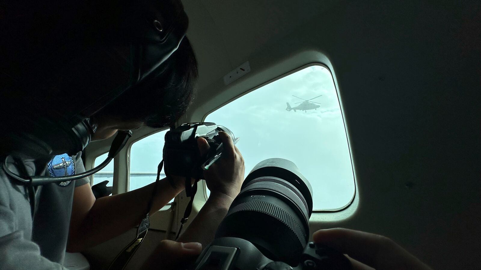 A Chinese military helicopter flies close to a Philippine Bureau of Fisheries and Aquatic (BFAR) aircraft above Scarborough shoal on Tuesday, Feb. 18, 2025. (AP Photo/Joeal Calupitan)