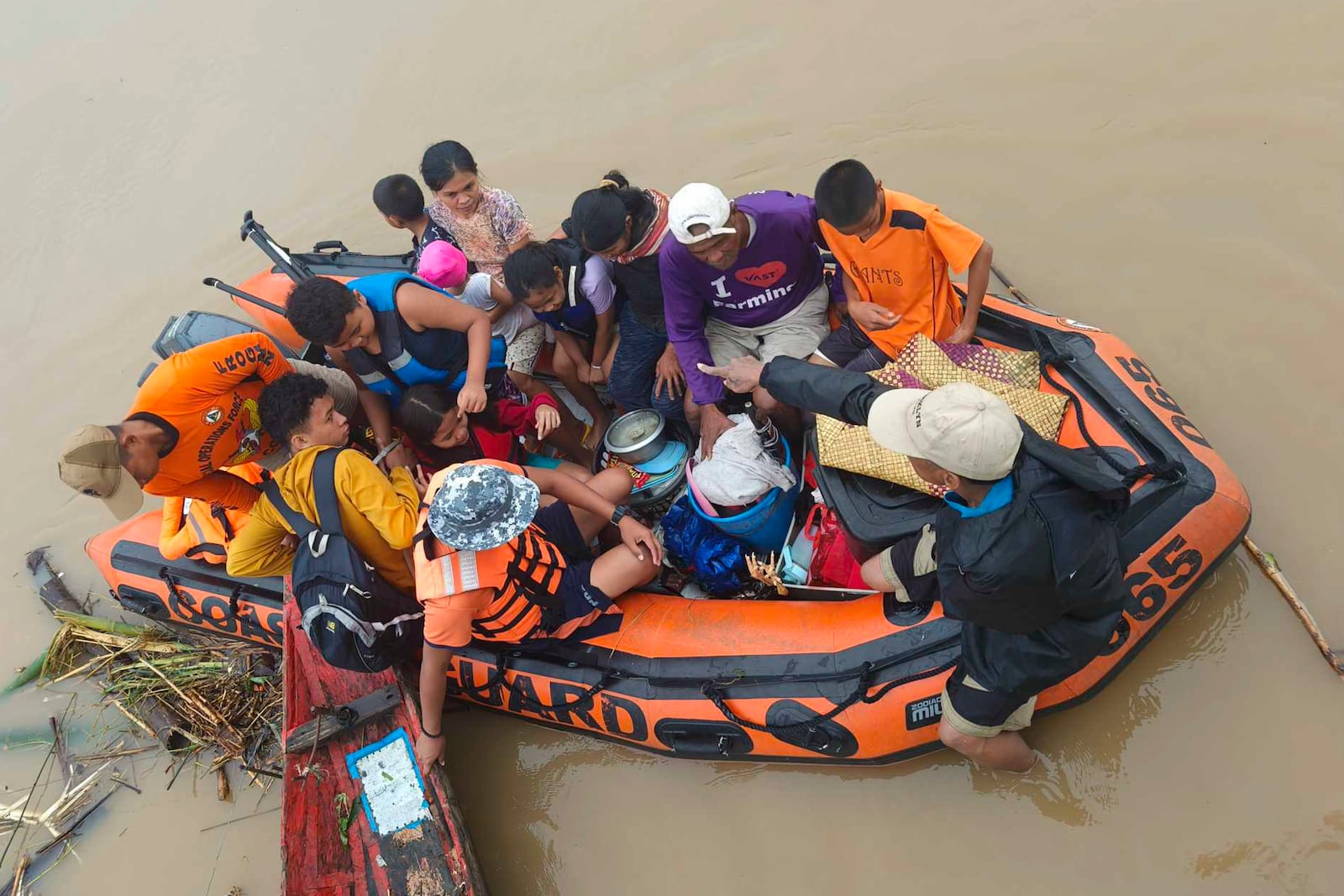 Residents are ferried on a rubber boat after being rescued from their roofs where they stayed to avoid high floods caused by Tropical Storm Trami hit Libon town, Albay province, Philippines on Wednesday Oct. 23, 2024. (Michelle Ricasio via AP)