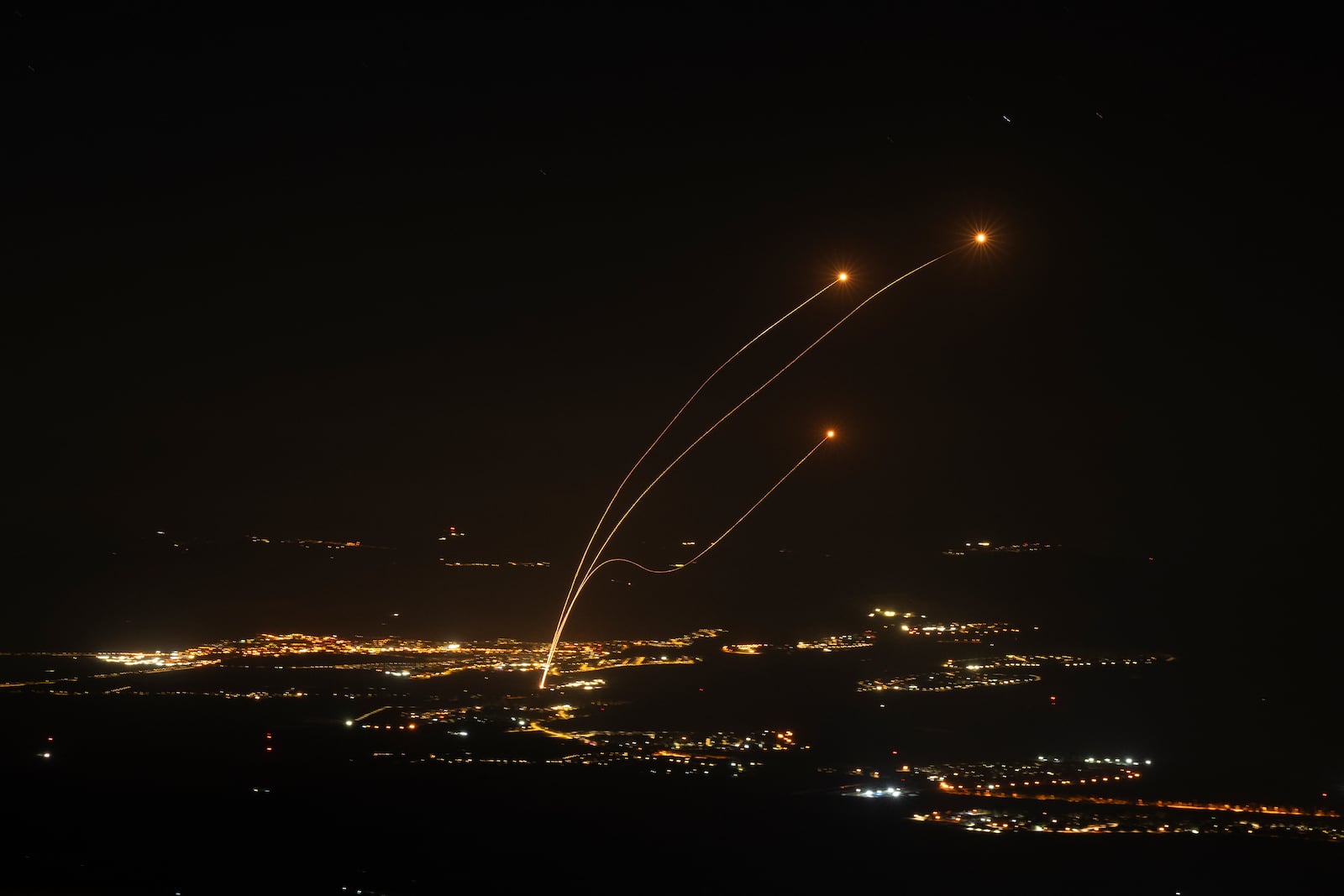 The Israeli Iron Dome air defense system fires to intercept rockets launched from Lebanon, near Kiryat Shmona, as seen from the Israeli-annexed Golan Heights, Saturday, Oct. 26, 2024. (AP Photo/Leo Correa)