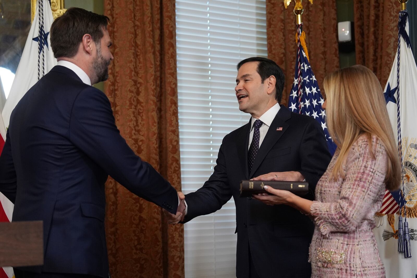 Secretary of State Marco Rubio shakes hands with Vice President JD Vance, after being sworn in, in the Vice Presidential Ceremonial Office in the Eisenhower Executive Office Building on the White House campus, Tuesday, Jan. 21, 2025, in Washington, as his wife, Jeanette Rubio, looks on. (AP Photo/Evan Vucci)