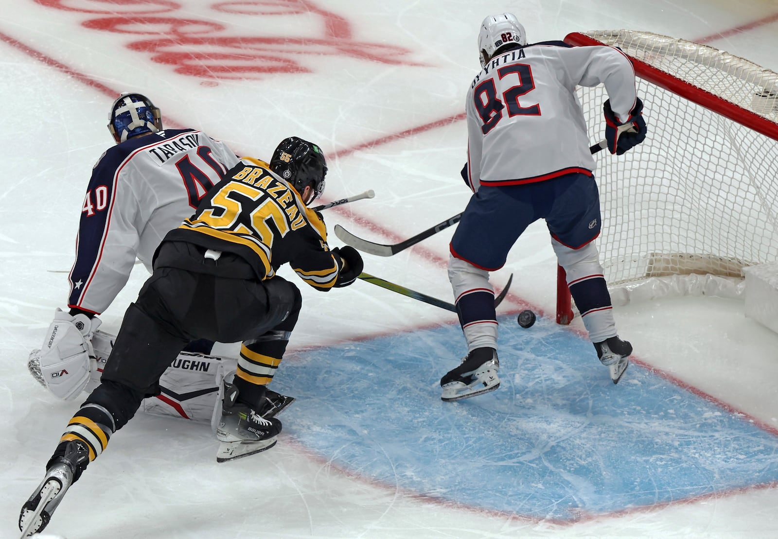 Boston Bruins forward Justin Brazeau (55) scores a goal as he slips the puck behind Columbus Blue Jackets goalie Daniil Tarasov and forward Mikael Pyyhtia (82) during the first period of an NHL hockey game Saturday, Dec. 28, 2024, in Boston. (AP Photo/Jim Davis)