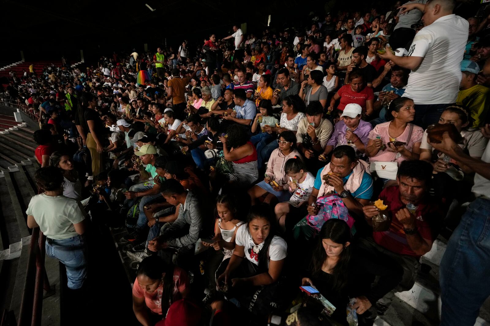 People displaced by violence in towns across the Catatumbo region, where rebels of the National Liberation Army, or ELN, have been clashing with former members of the Revolutionary Armed Forces of Colombia, take shelter at a soccer stadium in Cúcuta, Colombia, Sunday, Jan. 19, 2025. (AP Photo/Fernando Vergara)