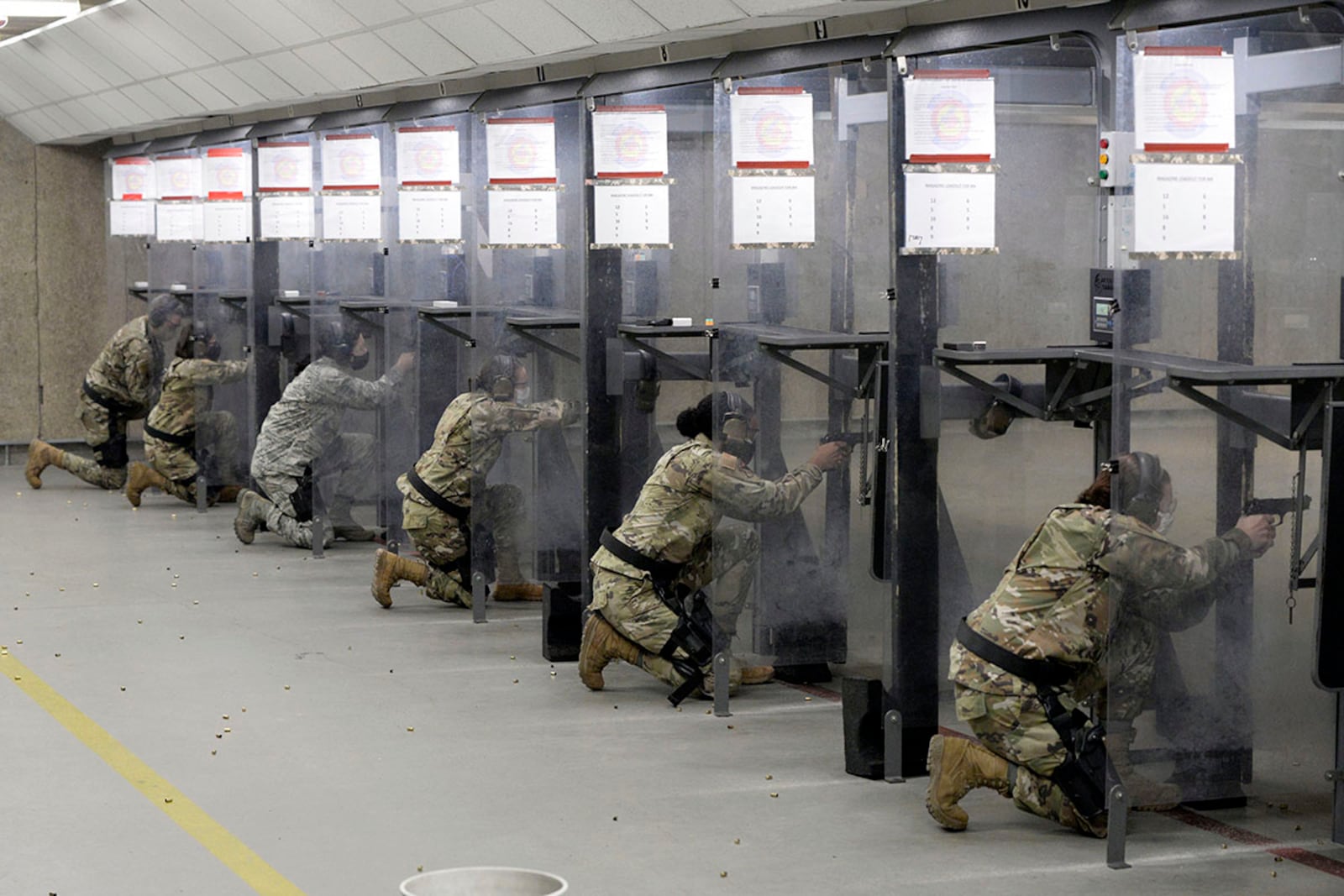 Personnel with the 88th Medical Group shoot from the kneeling position inside the 88th Security Forces Squadron’s Combat Arms firing range at Wright-Patterson Air Force Base on Feb. 18. U.S. AIR FORCE PHOTO/TY GREENLEES