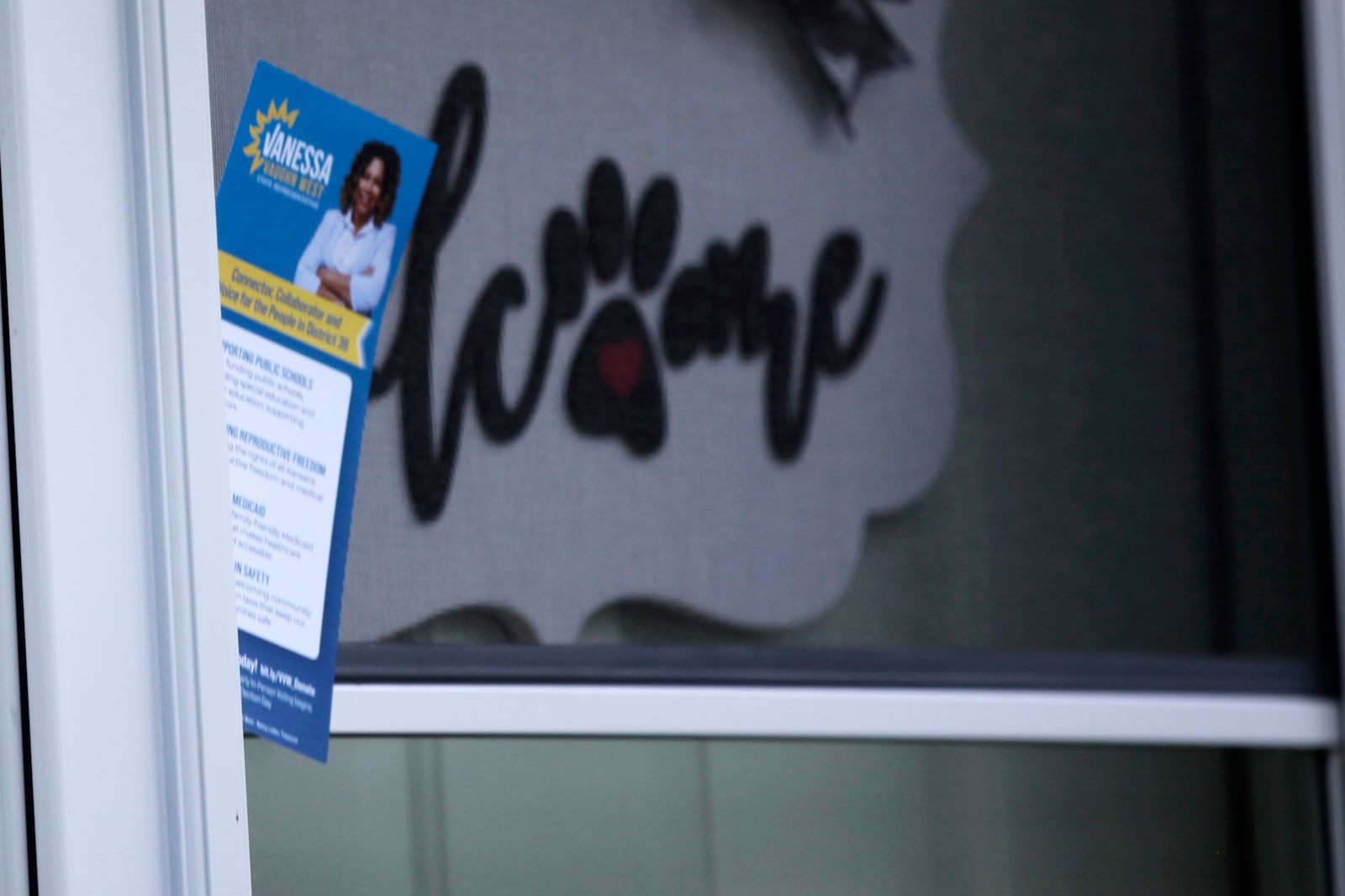 Democratic Kansas House candidate Vanessa Vaughn West leaves this campaign flyer at a home where the registered voter didn’t answer their door as she campaigned in her home neighborhood, Tuesday, Oct. 1, 2024, in Shawnee, Kansas. (AP Photo/John Hanna)