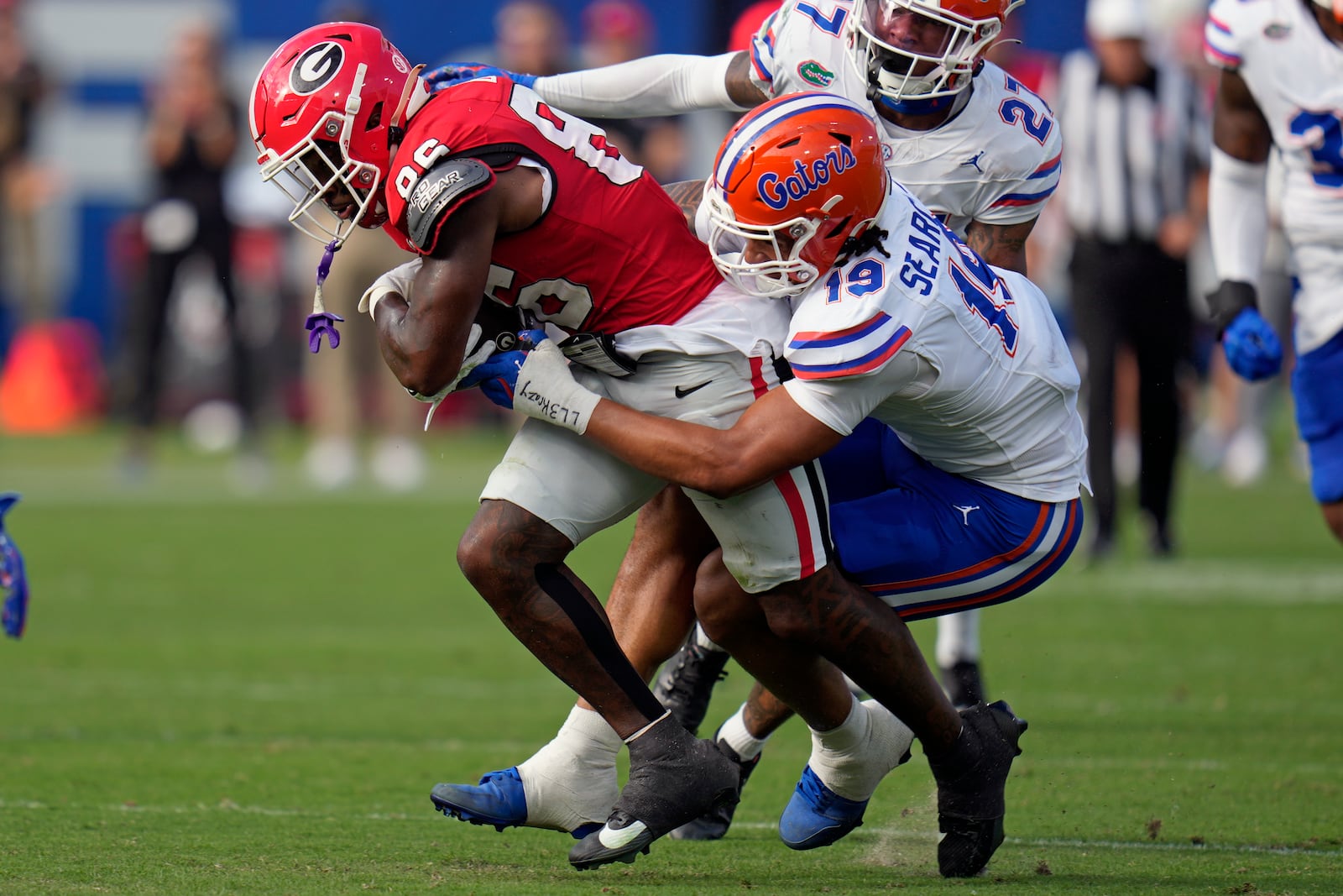 Florida edge T.J. Searcy, right, stops Georgia wide receiver Dillon Bell after a reception during the first half of an NCAA college football game, Saturday, Nov. 2, 2024, in Jacksonville, Fla. (AP Photo/John Raoux)