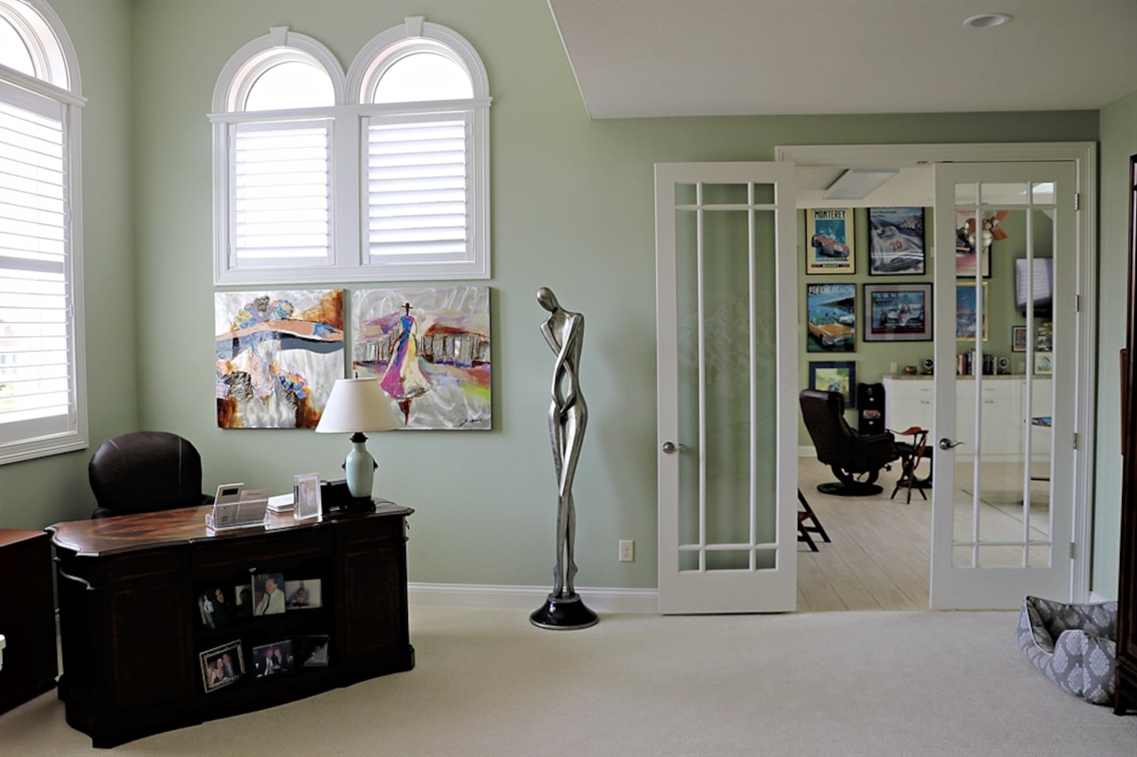 Upstairs, French doors open into a flexible space that is currently a combined office and hobby area.