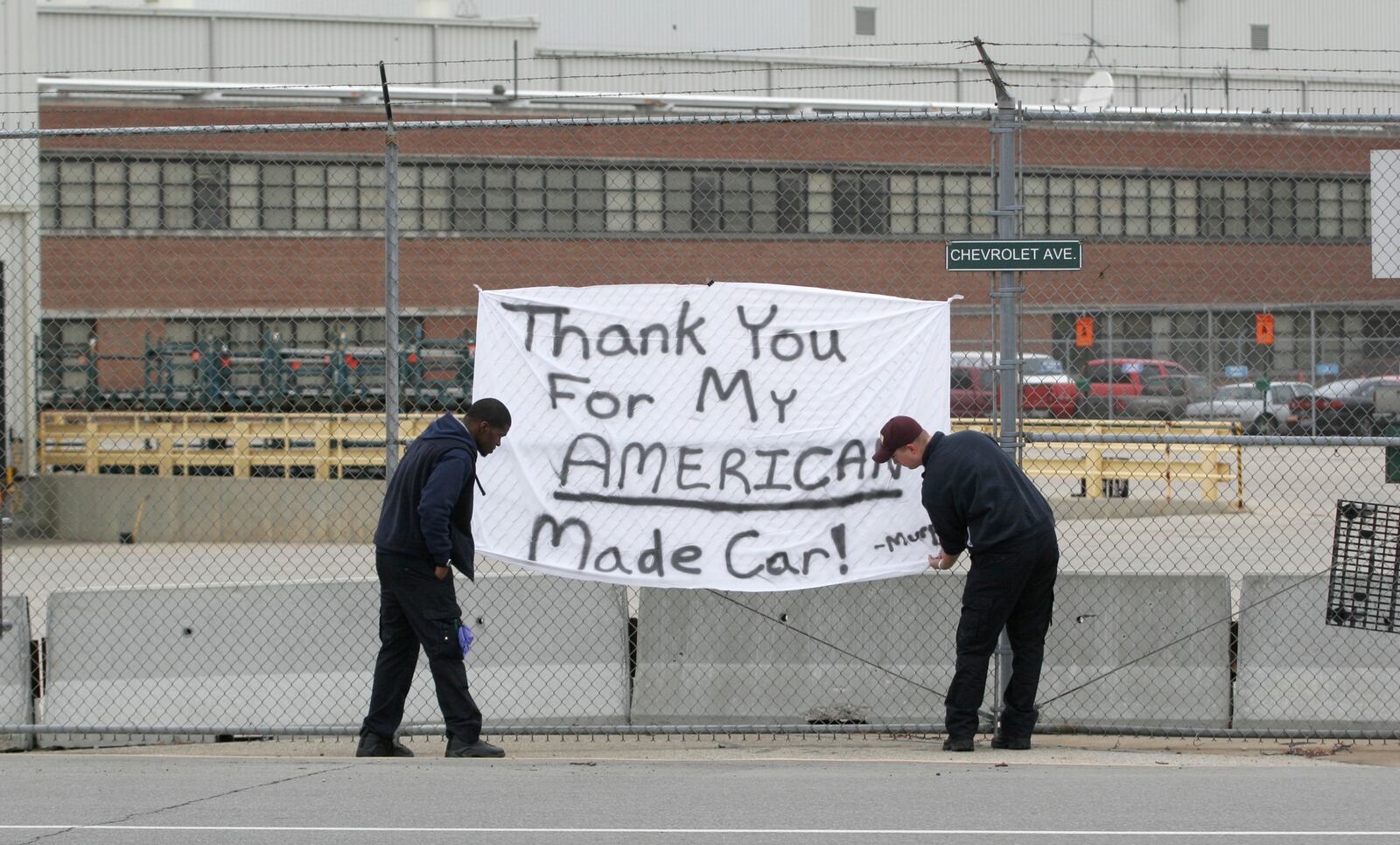 Raman Guy, left, of Springfield and Mark Murphy, right, of Beavercreek made a banner thanking GM Moraine Assembly Plant workers. Murphy’s grandfather worked at the plant, retiring about 15 years ago.