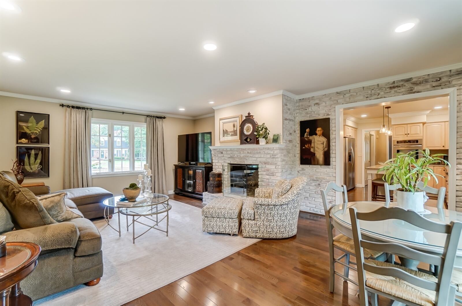 White bricks accent the wall and surround the fireplace within the family room. The fireplace has a raised hearth. 