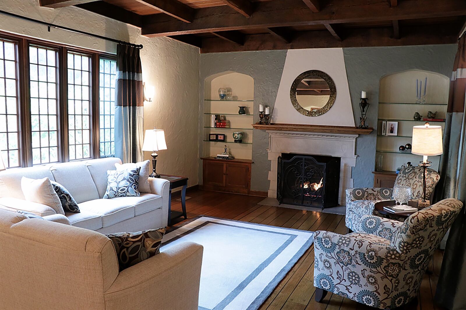 Two steps down off the foyer hallway is the casual family room with hardwood flooring and a wood coffered ceiling. A picture window faces front while two tall windows look out over the back yard. A gas fireplace has a wood-beam mantel and raised stucco accent surrounding the fireplace opening. CONTRIBUTED PHOTO BY KATHY TYLER