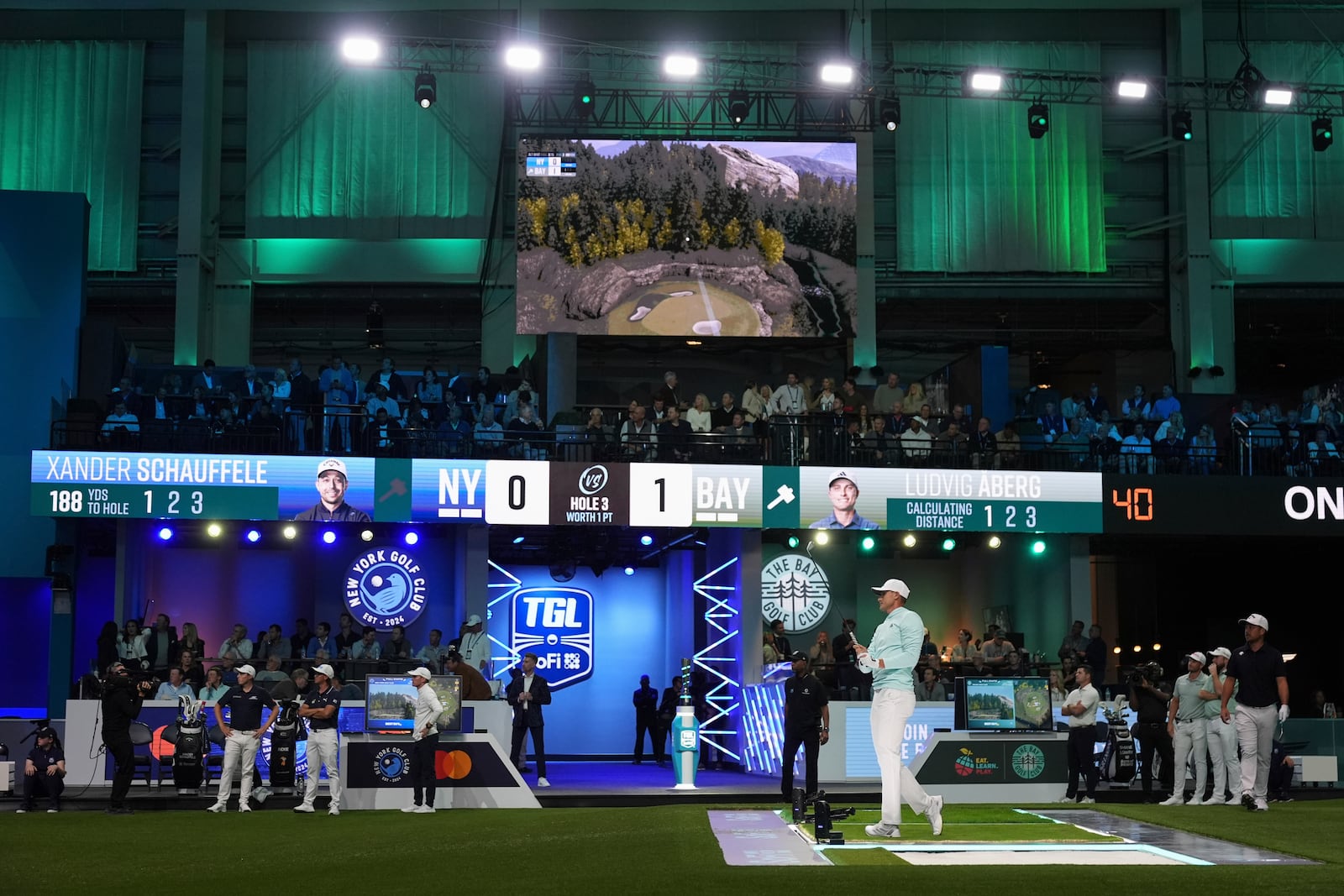 Ludvig Aberg of the Bay Golf Club watches his shot projected on a digital screen during the inaugural match of the TMRW Golf League, against New York Golf Club, Tuesday, Jan. 7, 2025, in Palm Beach Gardens, Fla. TGL features six teams of four players competing against each other in a tech-infused arena the size of a football field. (AP Photo/Rebecca Blackwell)