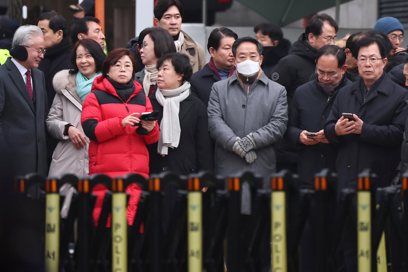 Members of the ruling People Power Party wait for the arrival of investigators from the Corruption Investigation Office for High-ranking Officials, outside the residence of impeached South Korean President Yoon Suk Yeol in Seoul, South Korea, Monday, Jan. 6, 2025. (Kim In-chul/Yonhap via AP)