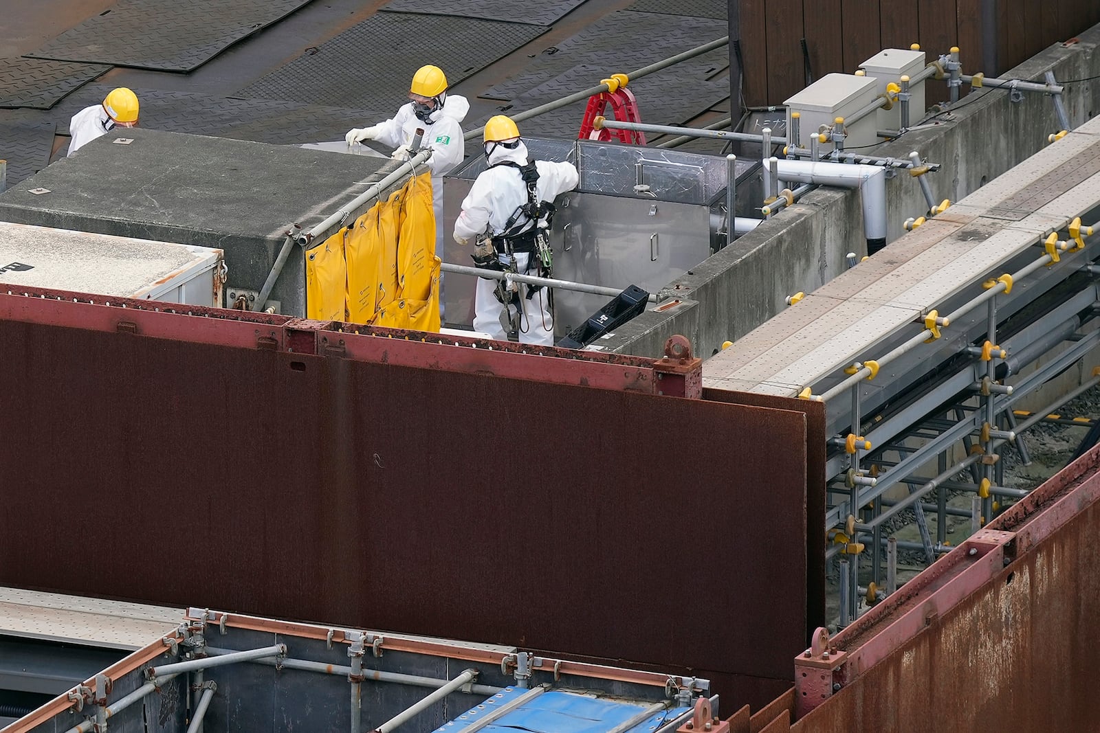 Workers in hazmat suits are seen at the Fukushima Daiichi nuclear power plant, operated by Tokyo Electric Power Company Holdings (TEPCO), in Okuma town, northeastern Japan on Monday Feb. 20, 2025. (AP Photo/Eugene Hoshiko)