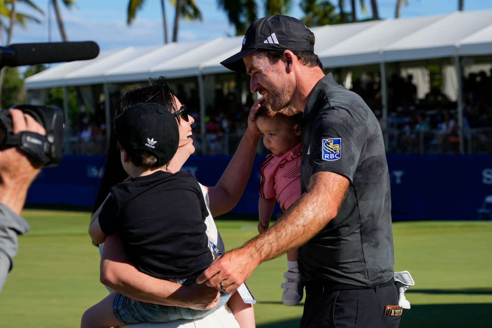 Nick Taylor, of Canada, celebrates with his family after winning the Sony Open golf event in a playoff, Sunday, Jan. 12, 2025, at Waialae Country Club in Honolulu. (AP Photo/Matt York)