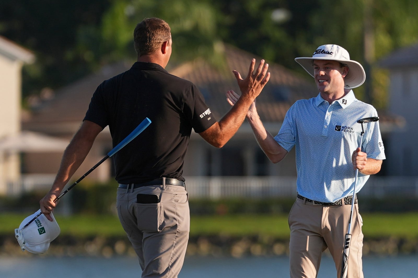 Joe Highsmith, right, clasps hands with Taylor Montgomery after finishing on the 18th hole during the final round of the Cognizant Classic golf tournament, Sunday, March 2, 2025, in Palm Beach Gardens, Fla. (AP Photo/Rebecca Blackwell)