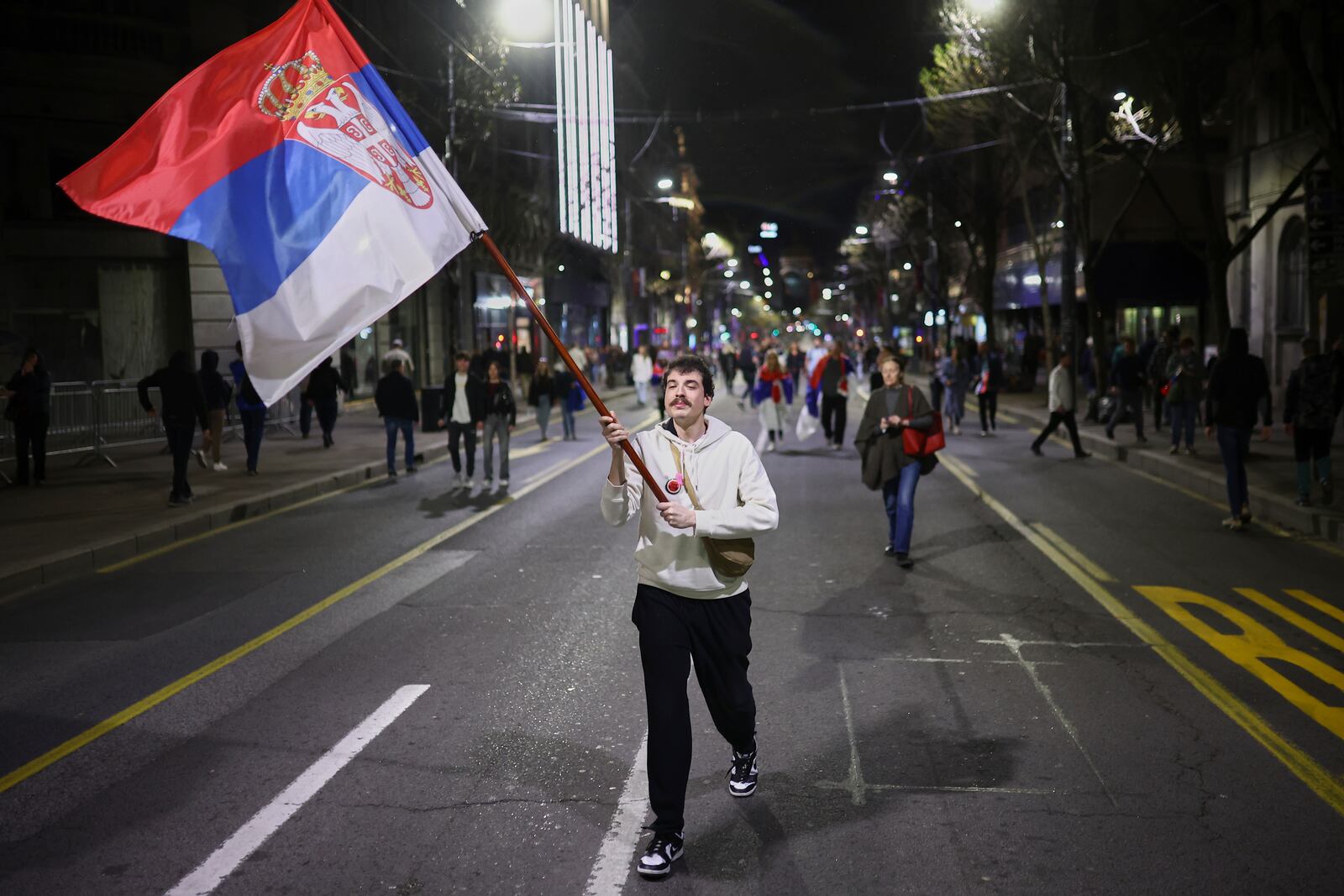 A man wave the Serbian flag ahead of a major rally this weekend in downtown Belgrade, Serbia, Friday, March 14, 2025. (AP Photo/Armin Durgut)