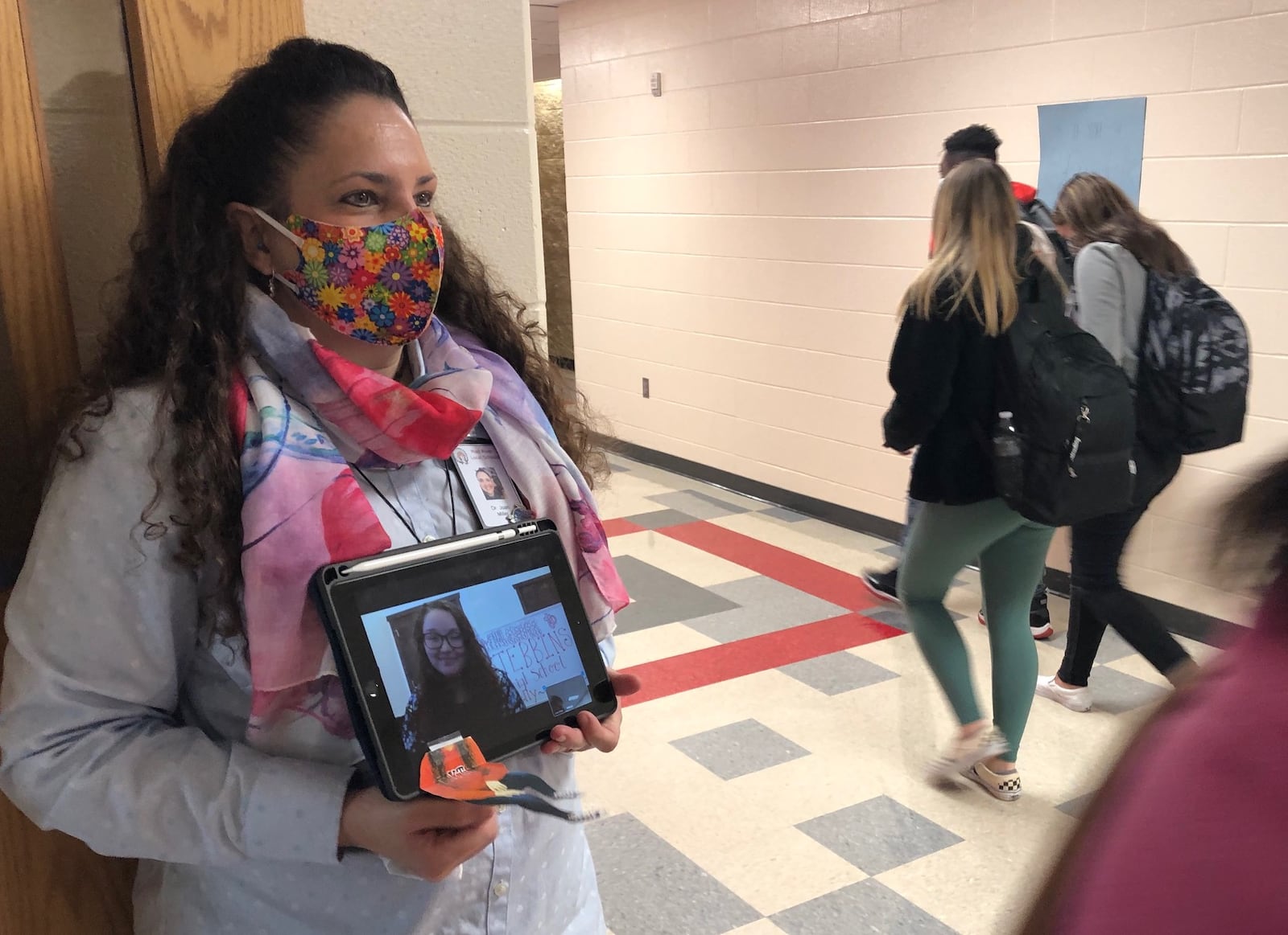 Stebbins High School art teacher Joan Miller makes sure virtual student teacher Hannah Kelly gets the full experience, carrying her (via iPad) outside the classroom for hall monitor duty during change of classes Thursday, Oct. 22. JEREMY P. KELLEY/STAFF