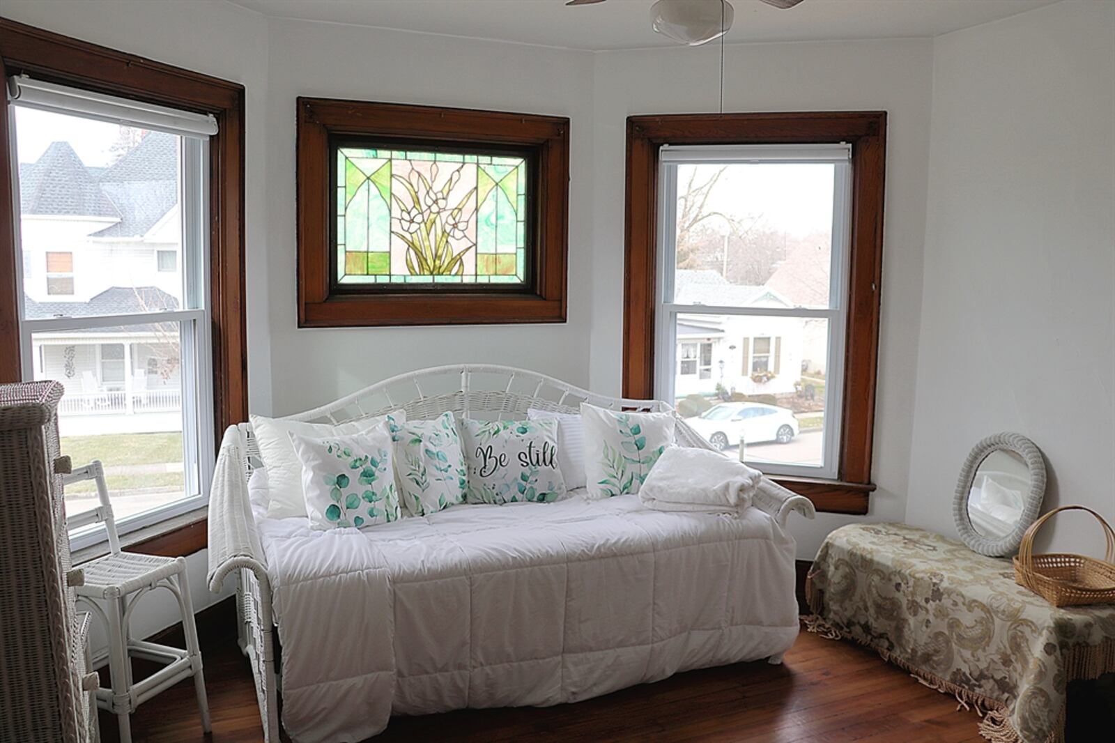 A front bedroom has a bay design with a stained-glass window flanked by two windows. 