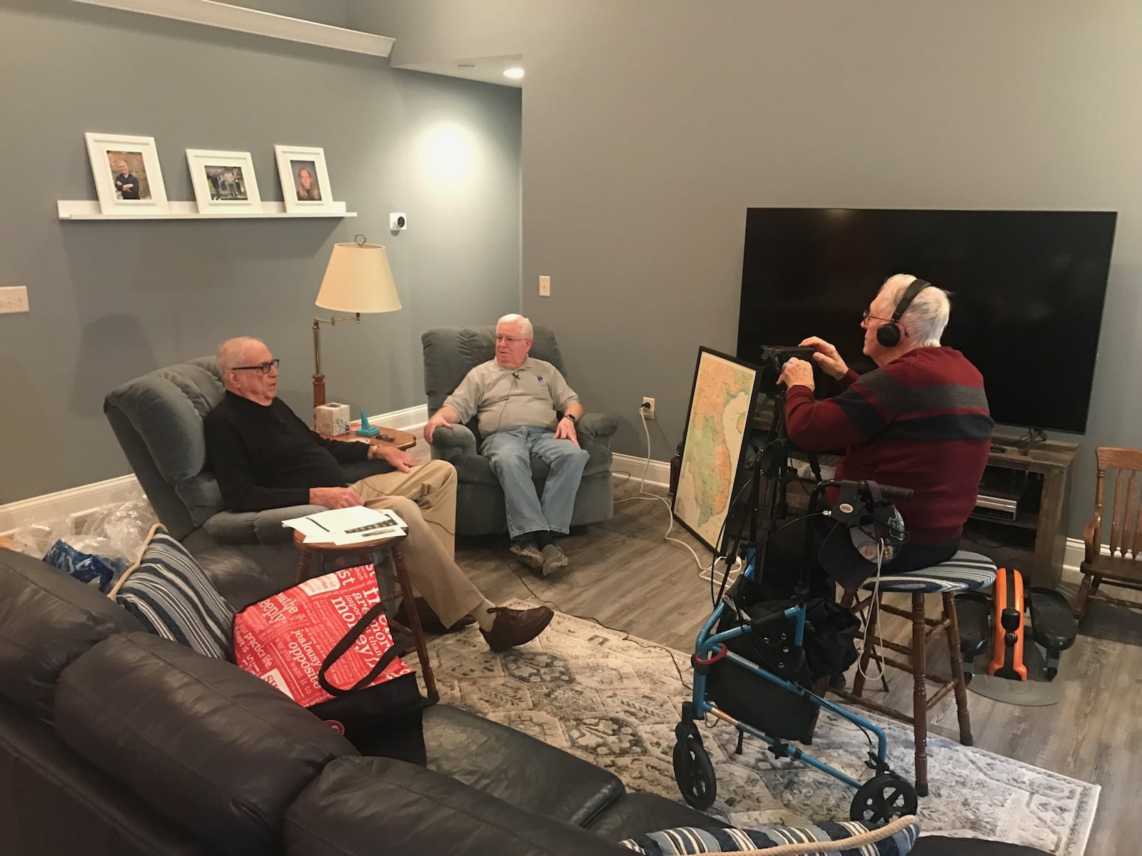 Pat Allen (left) interviews Vietnam veteran, Mark Deam in his Sidney home as Jim O’Donnell, a Navy veteran from Covington, runs the video camera. Tom Archdeacon/CONTRIBUTED